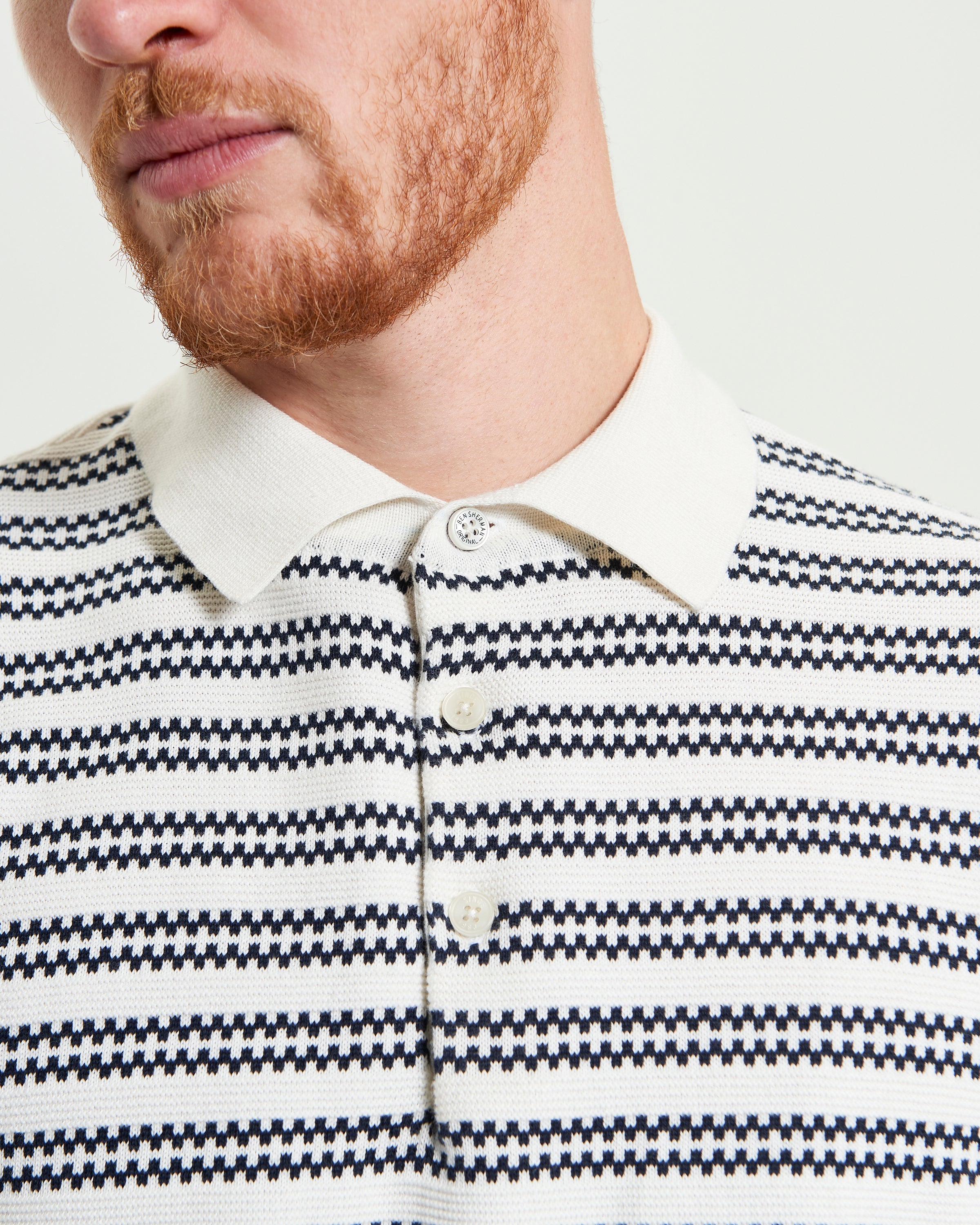 Jacquard Stripe Polo – Short-sleeve knit with intricate stripe pattern, ribbed collar, and buttons.