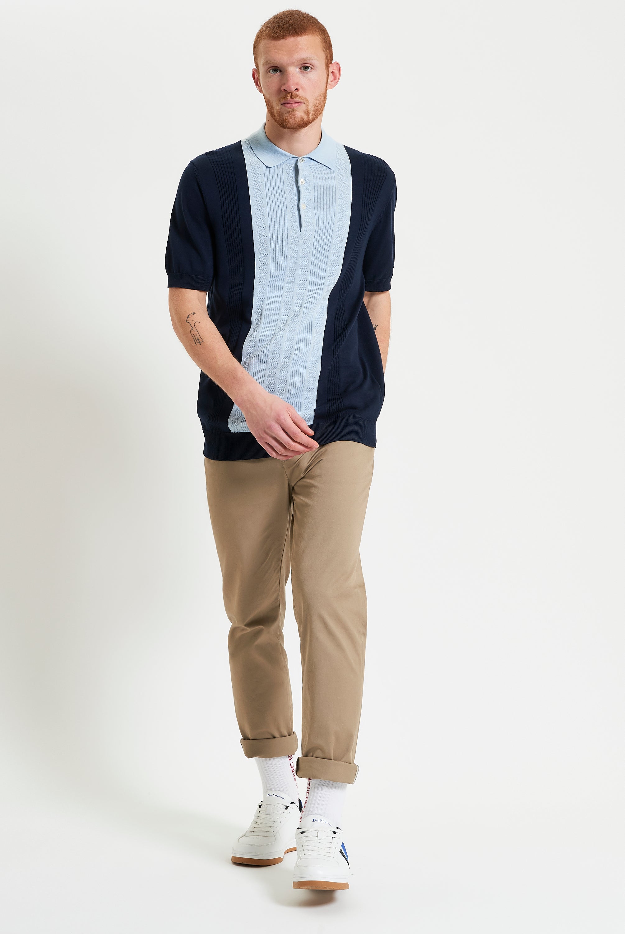 Textured Block Stripe Polo – navy and light blue short sleeve polo worn by man with beige pants and white sneakers.