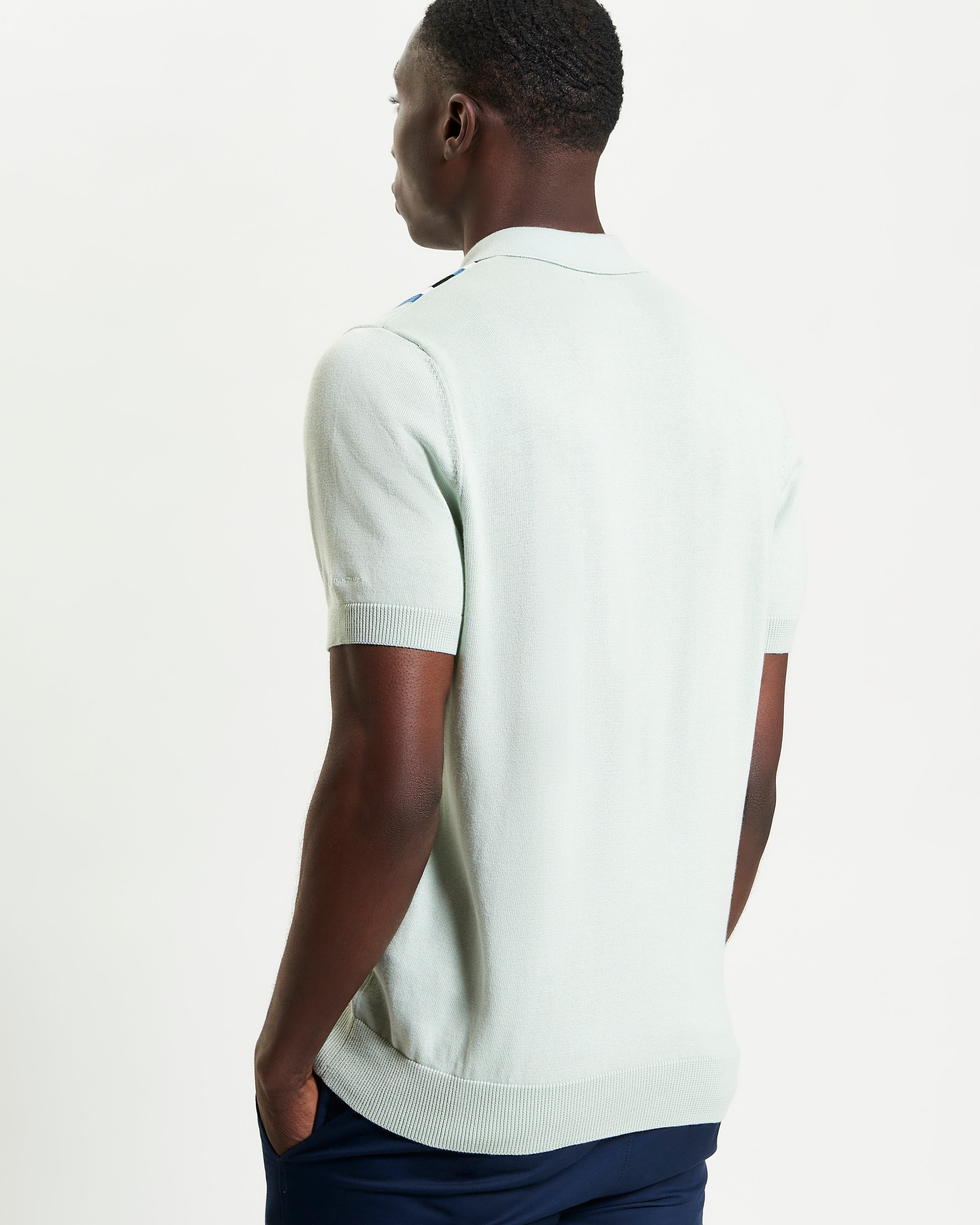 Vertical Stripe Polo – Back view of a man wearing a light green polo shirt with a stylish fit.