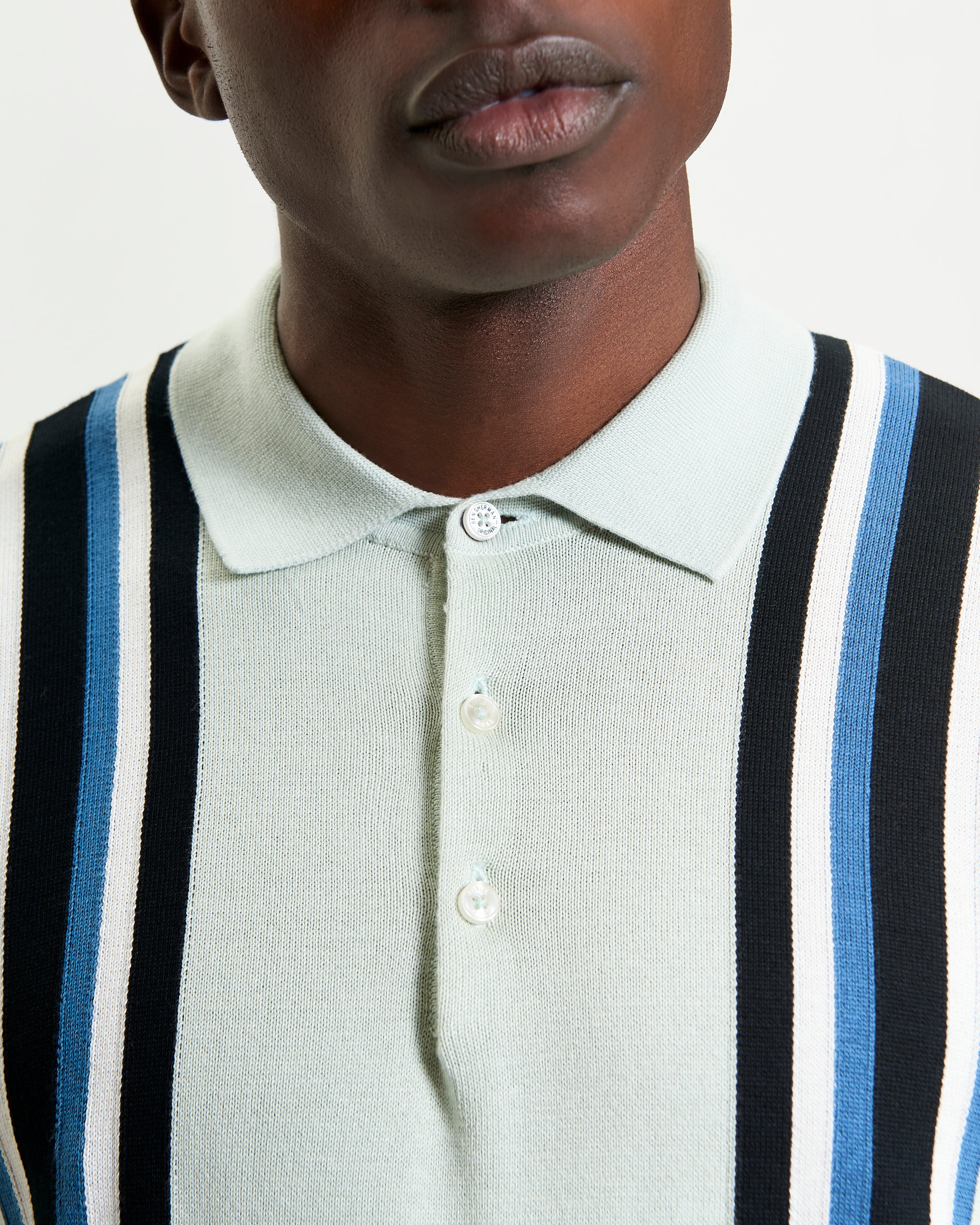 Vertical Stripe Polo – stylish knit with bold stripes and a three-button placket, perfect for weekend wear.