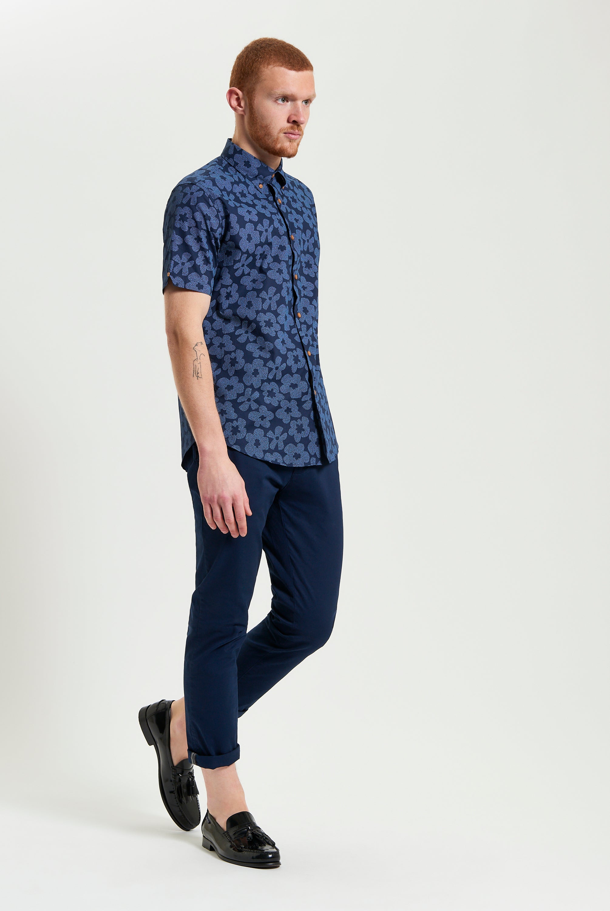 Stipple Floral Print – a man wearing a navy floral shirt paired with tailored pants and black loafers.