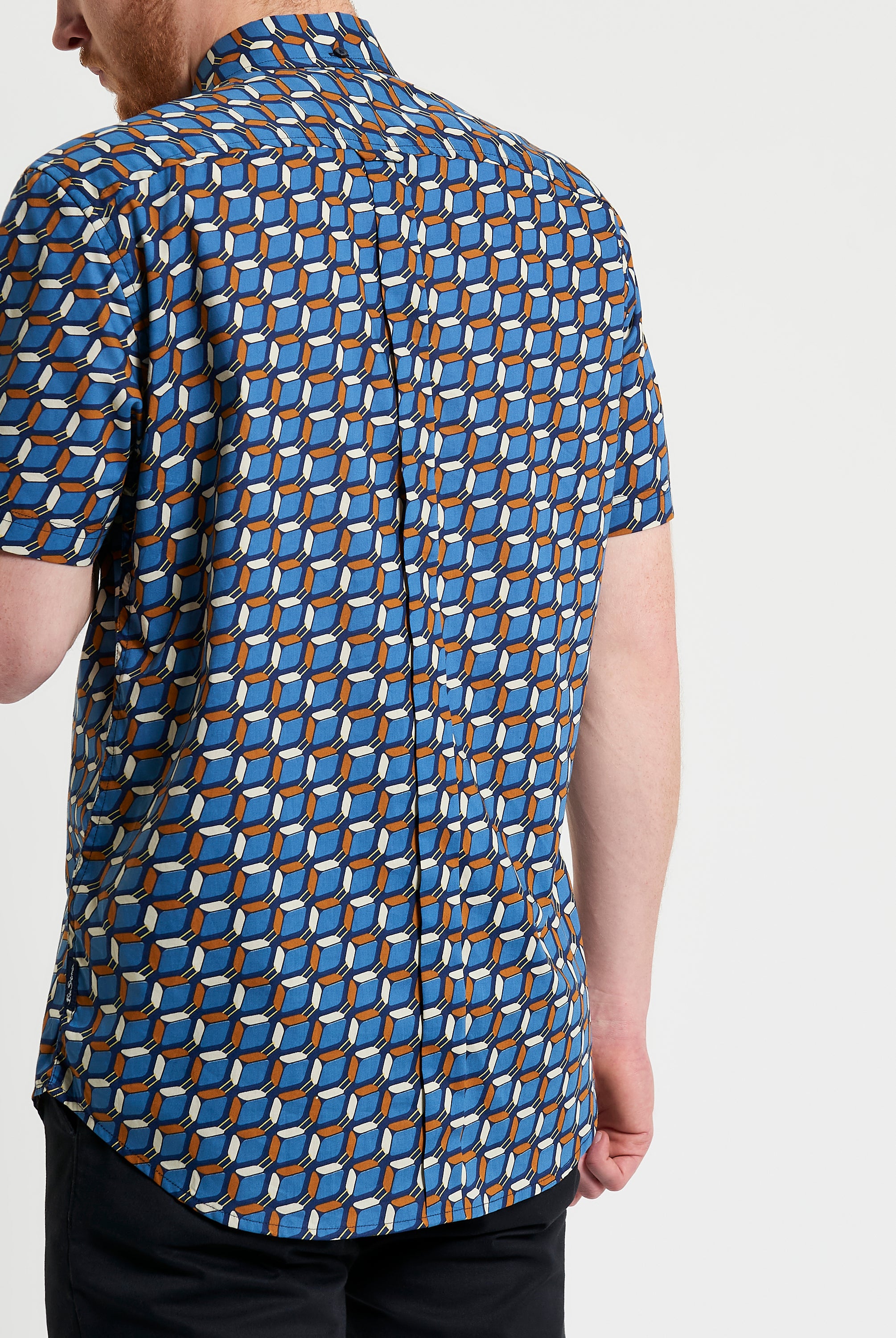Retro Geo Print shirt showcasing a bold geometric pattern on a blue background, featuring a relaxed fit and unique collar.