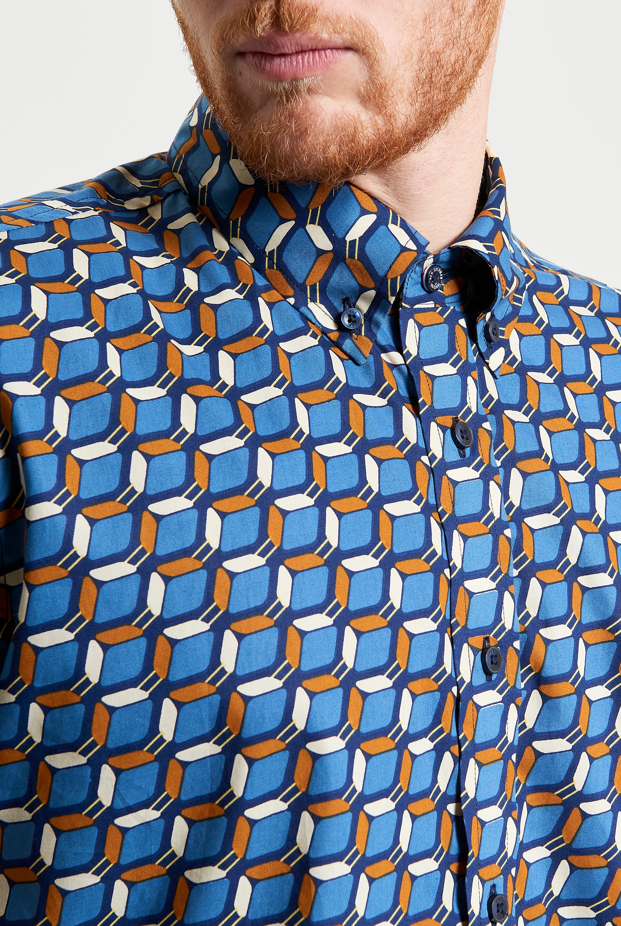 Retro Geo Print shirt featuring a bold vintage-inspired geo pattern in blue, orange, and white.