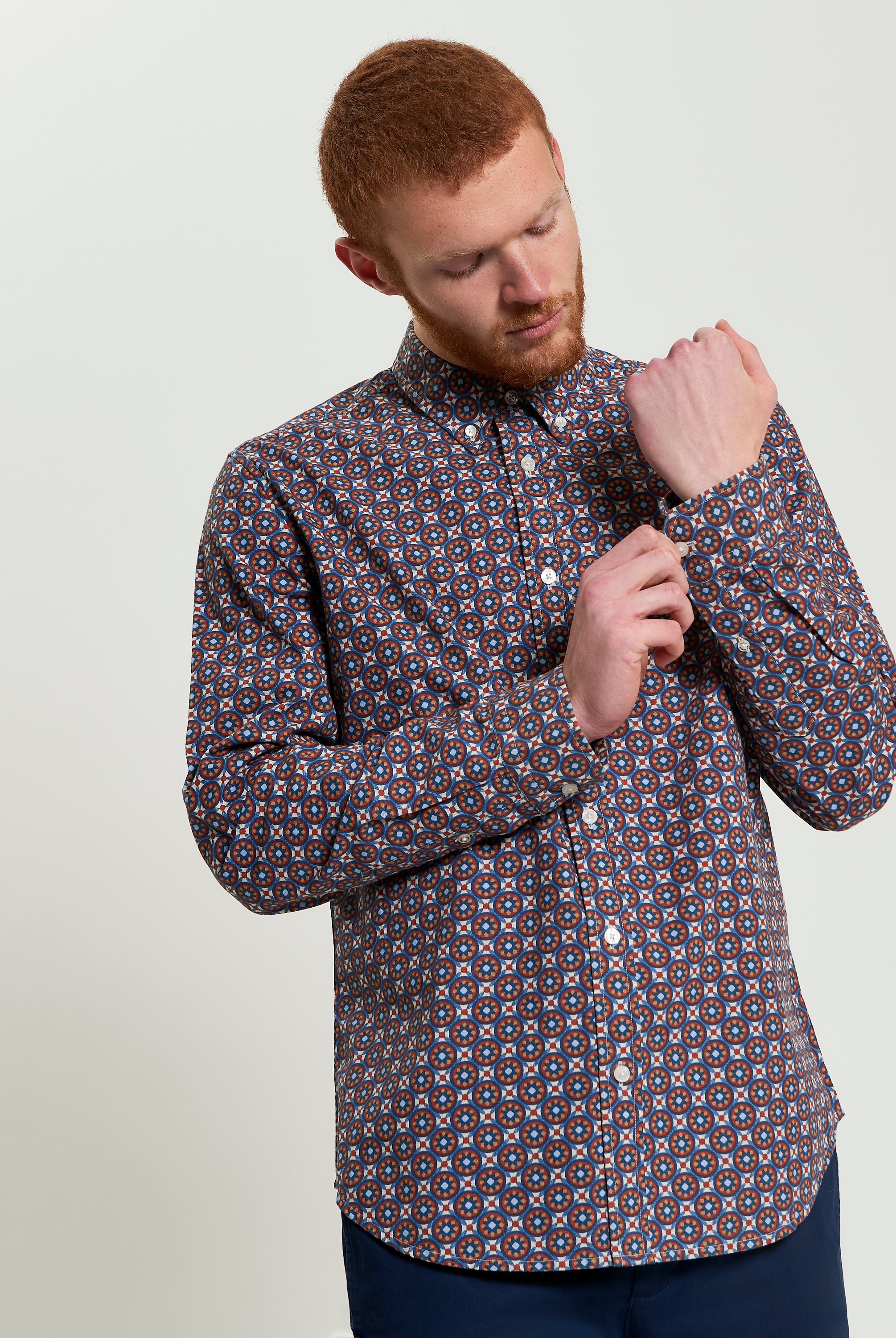 Man adjusting sleeves of Block Foulard Print long-sleeve shirt, perfect for smart-casual and office settings.
