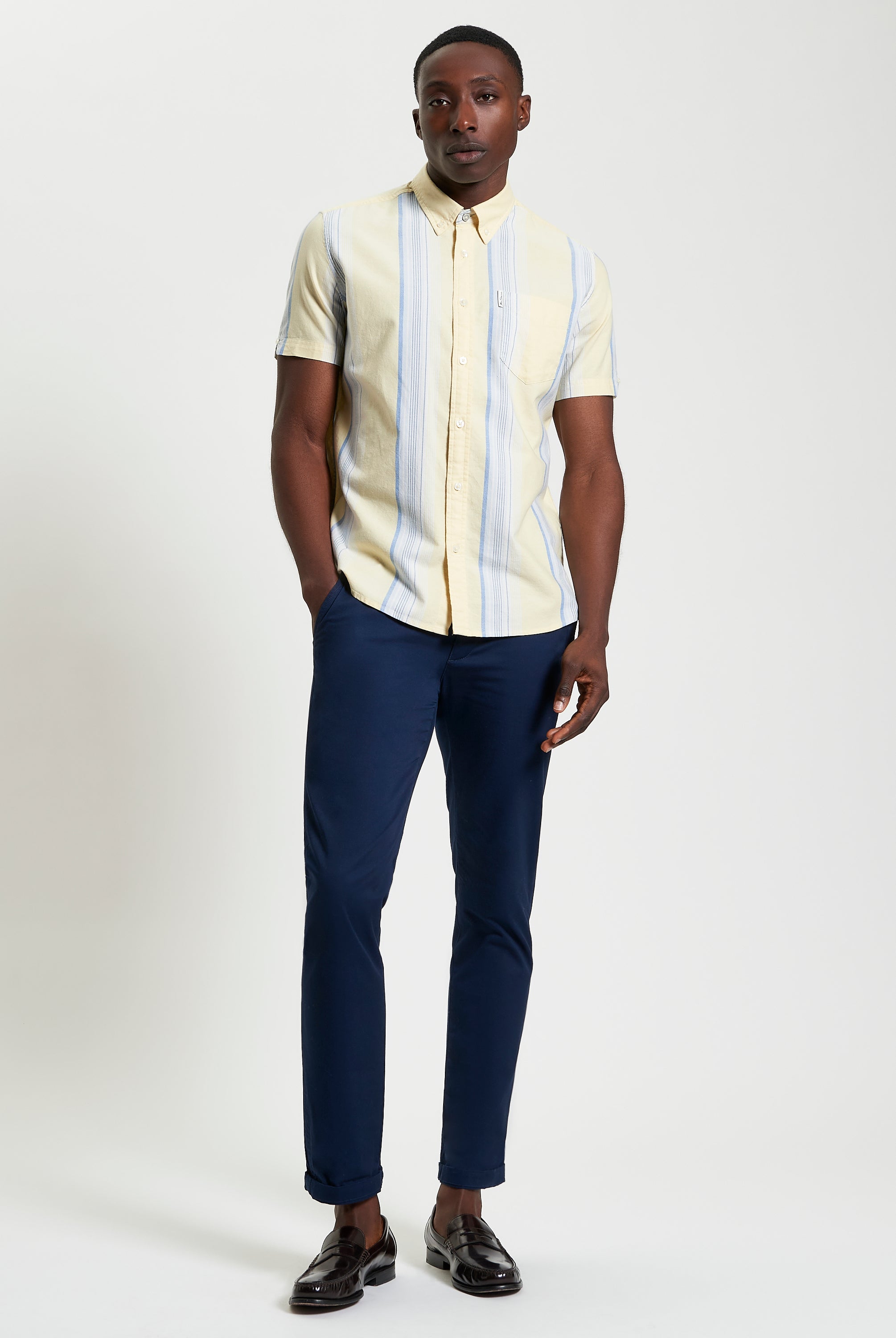 Oxford Stripe β Yellow short sleeve shirt paired with navy trousers for smart-casual style.