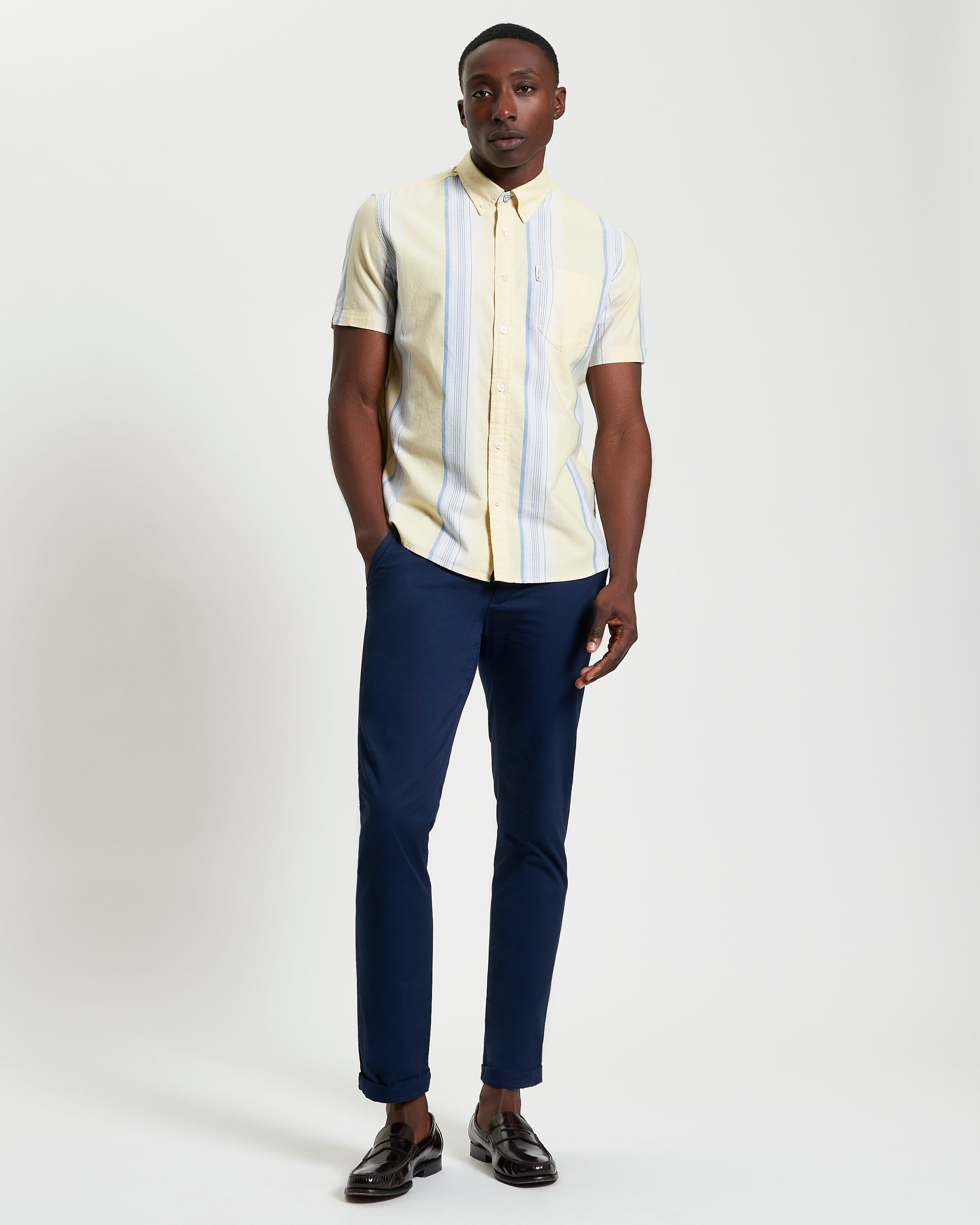 Oxford Stripe – Yellow short sleeve shirt paired with navy trousers for smart-casual style.