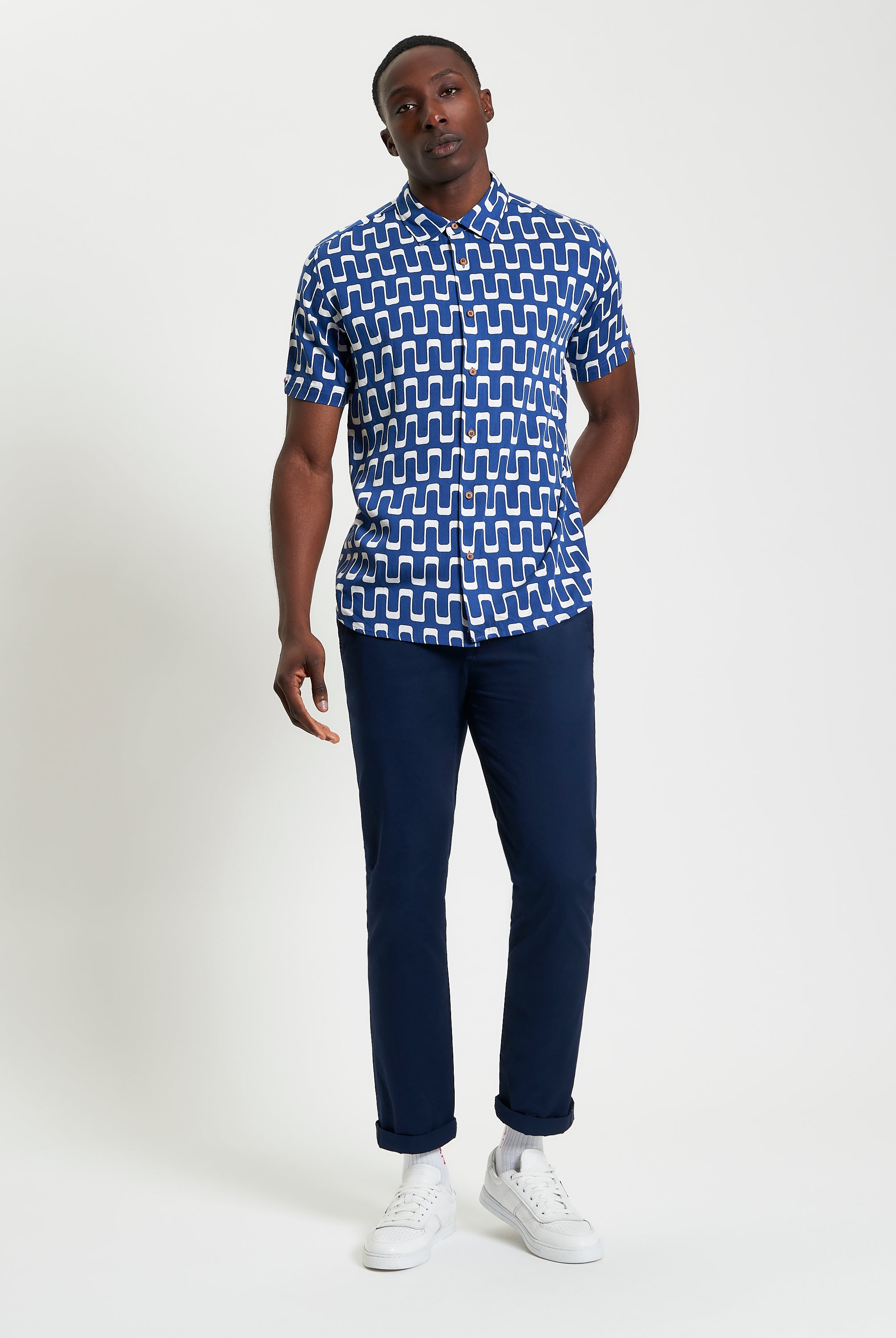 Jazz Print short sleeve shirt with abstract wave pattern, styled with navy trousers and white sneakers.