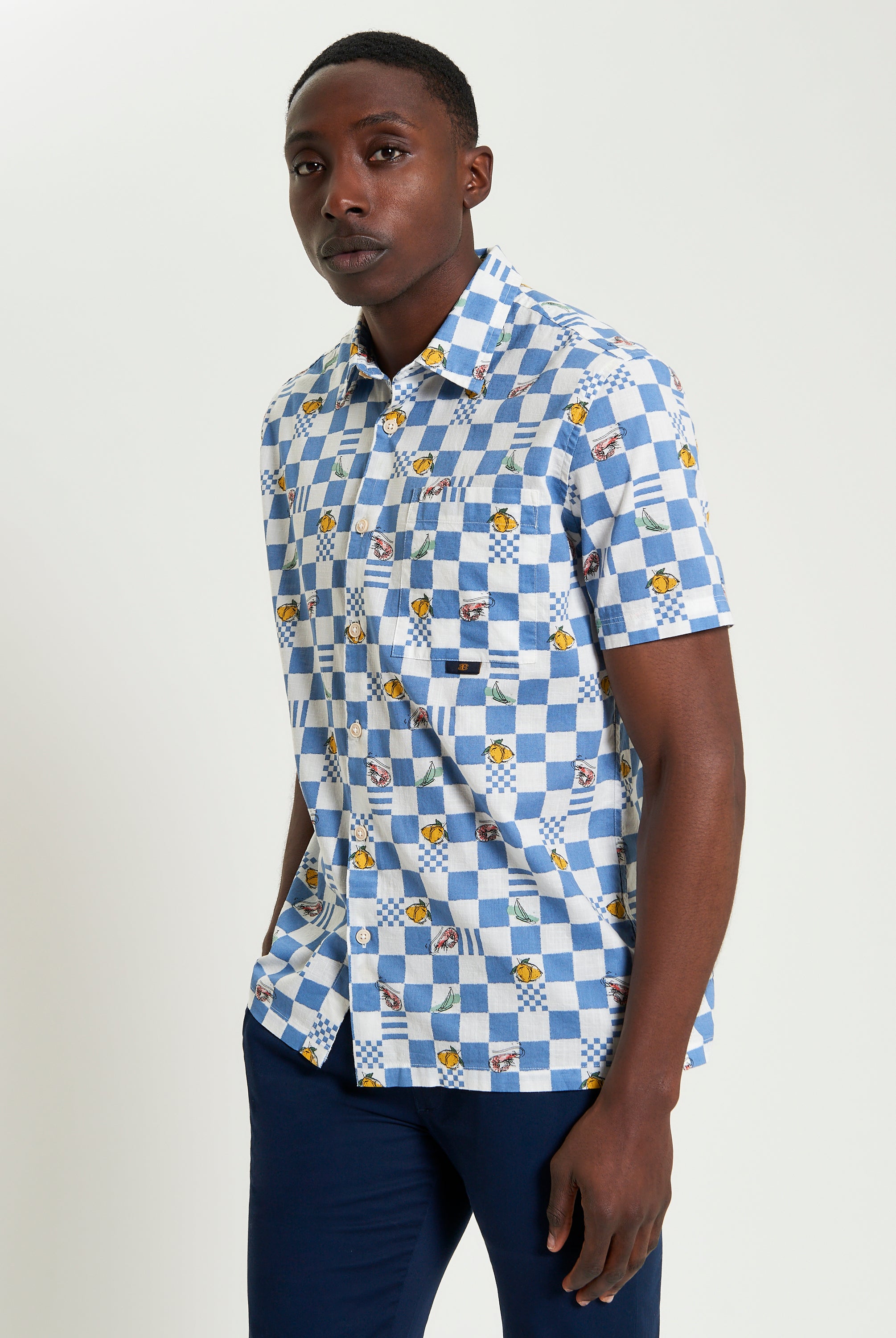 Chequerboard Print shirt in blue and white with graphic motifs and short sleeves, perfect for casual styling.