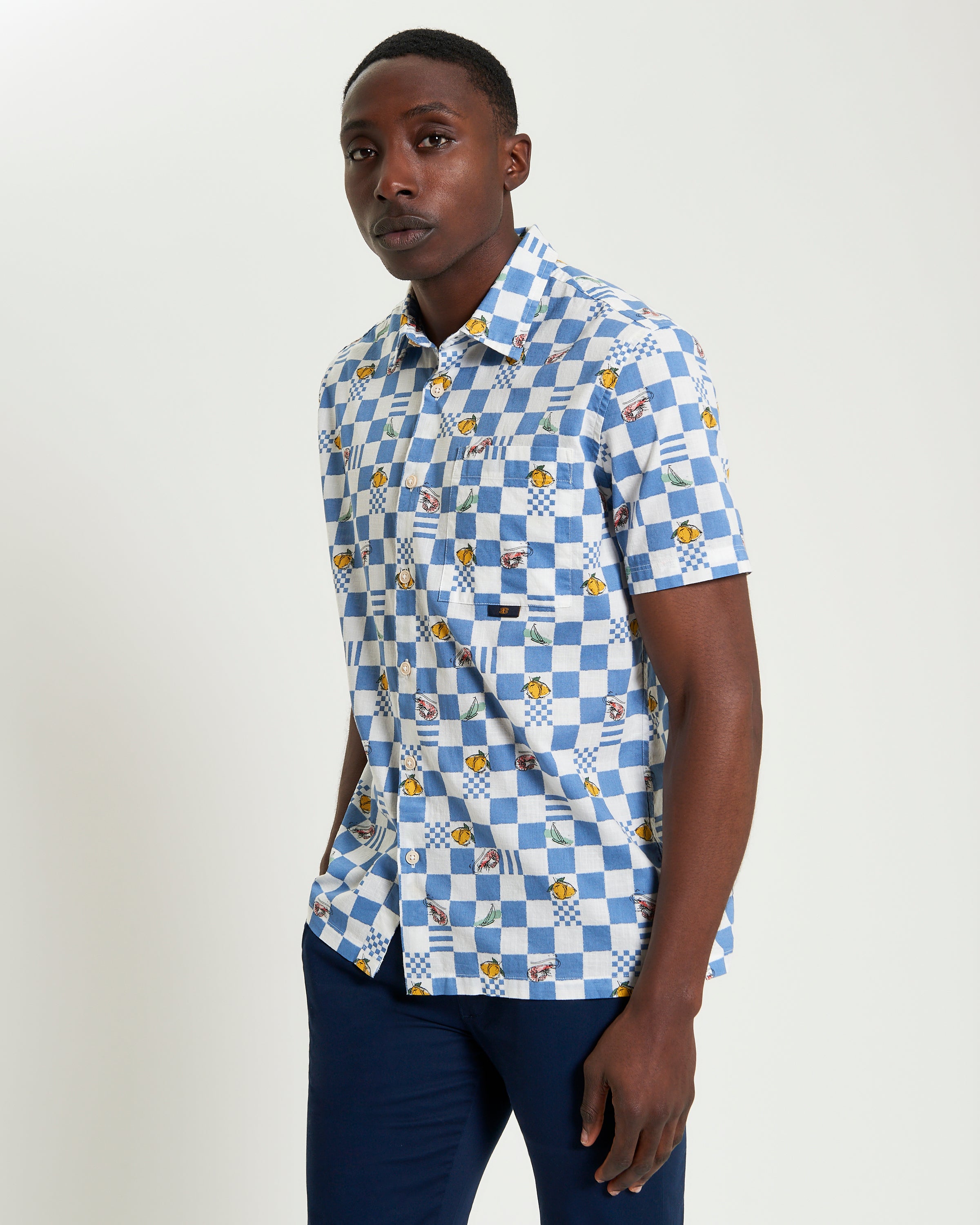 Chequerboard Print shirt in blue and white with graphic motifs and short sleeves, perfect for casual styling.