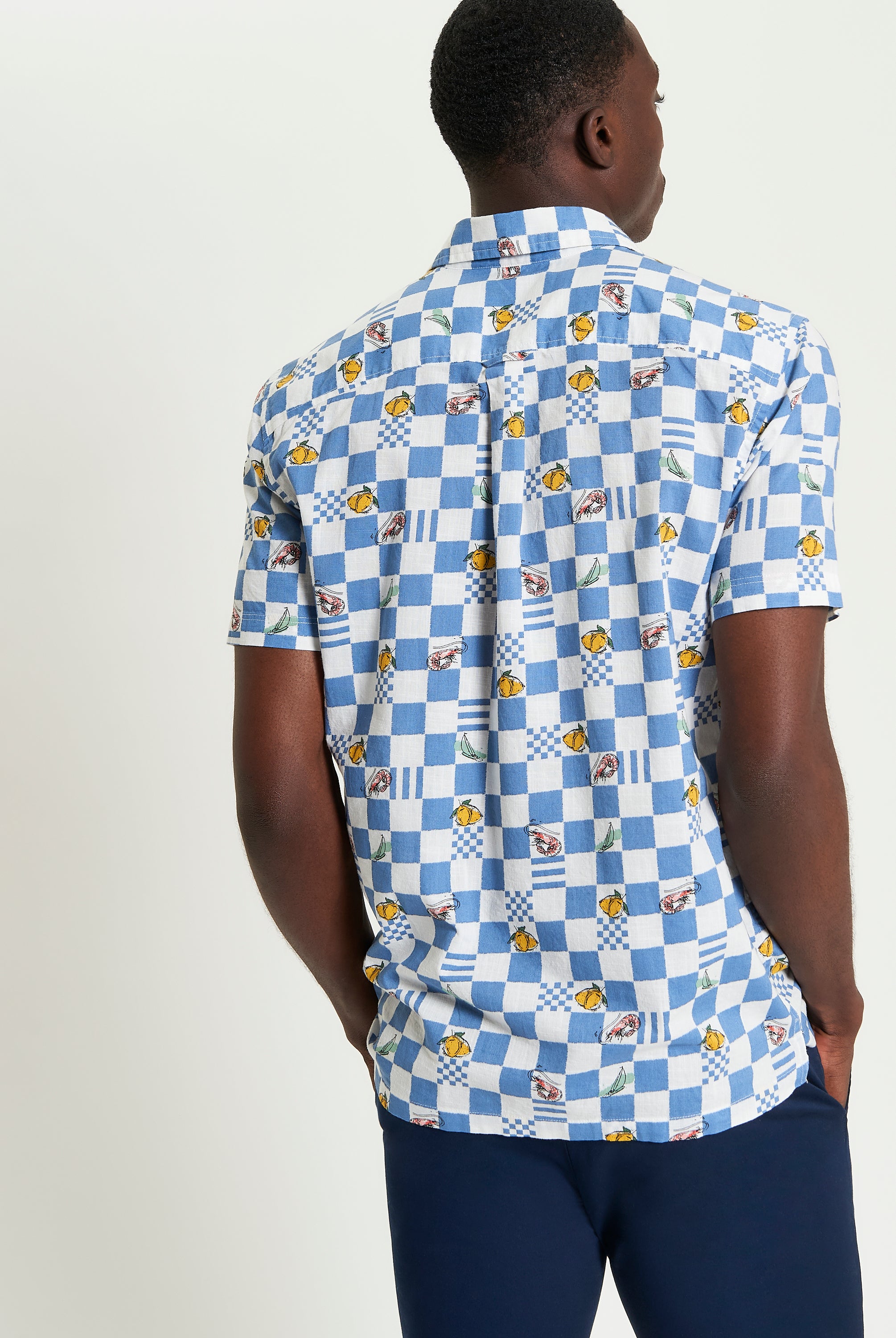 Chequerboard Print – Blue shirt showcasing a striking check pattern and classic tailoring details.