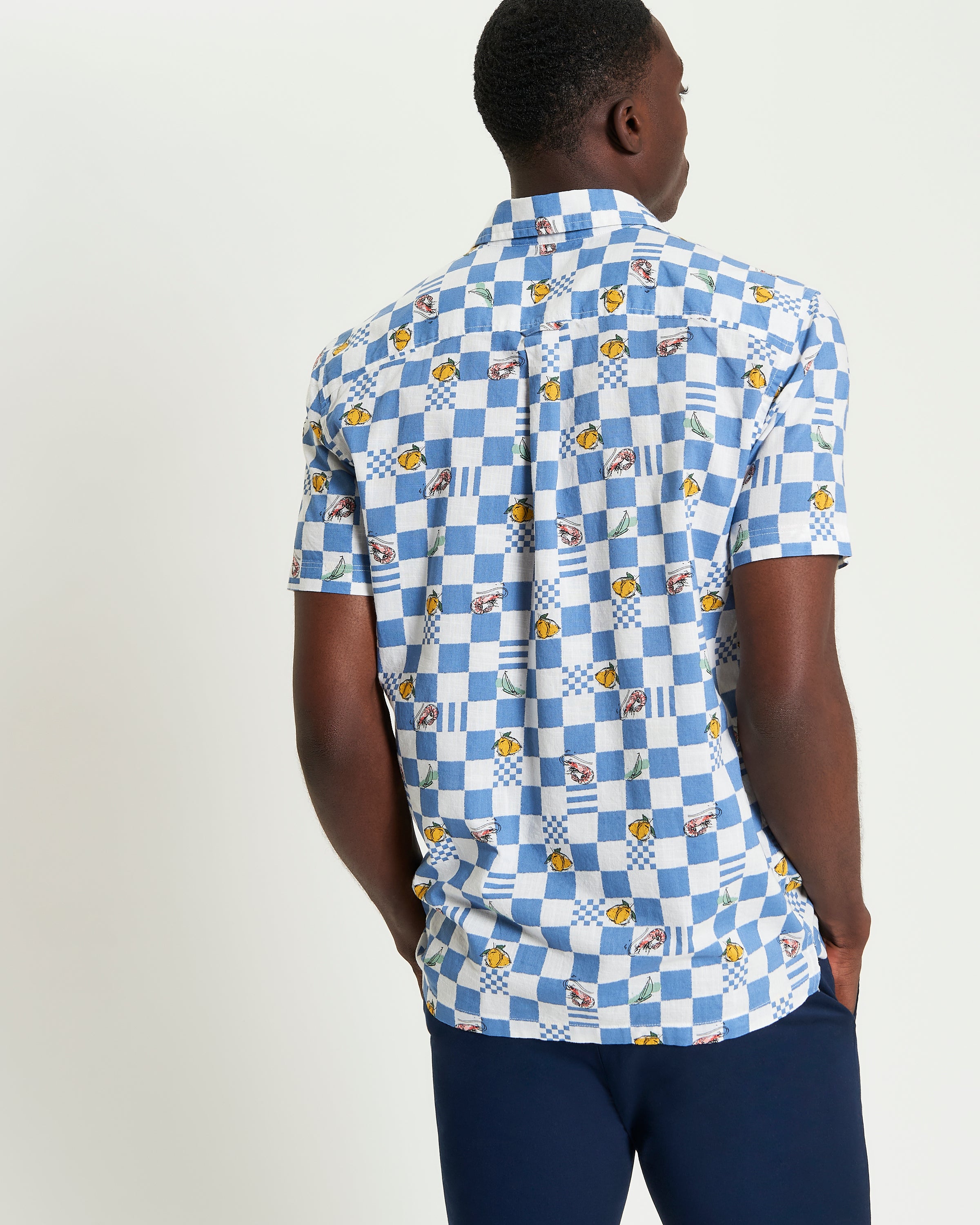 Chequerboard Print – Blue shirt showcasing a striking check pattern and classic tailoring details.