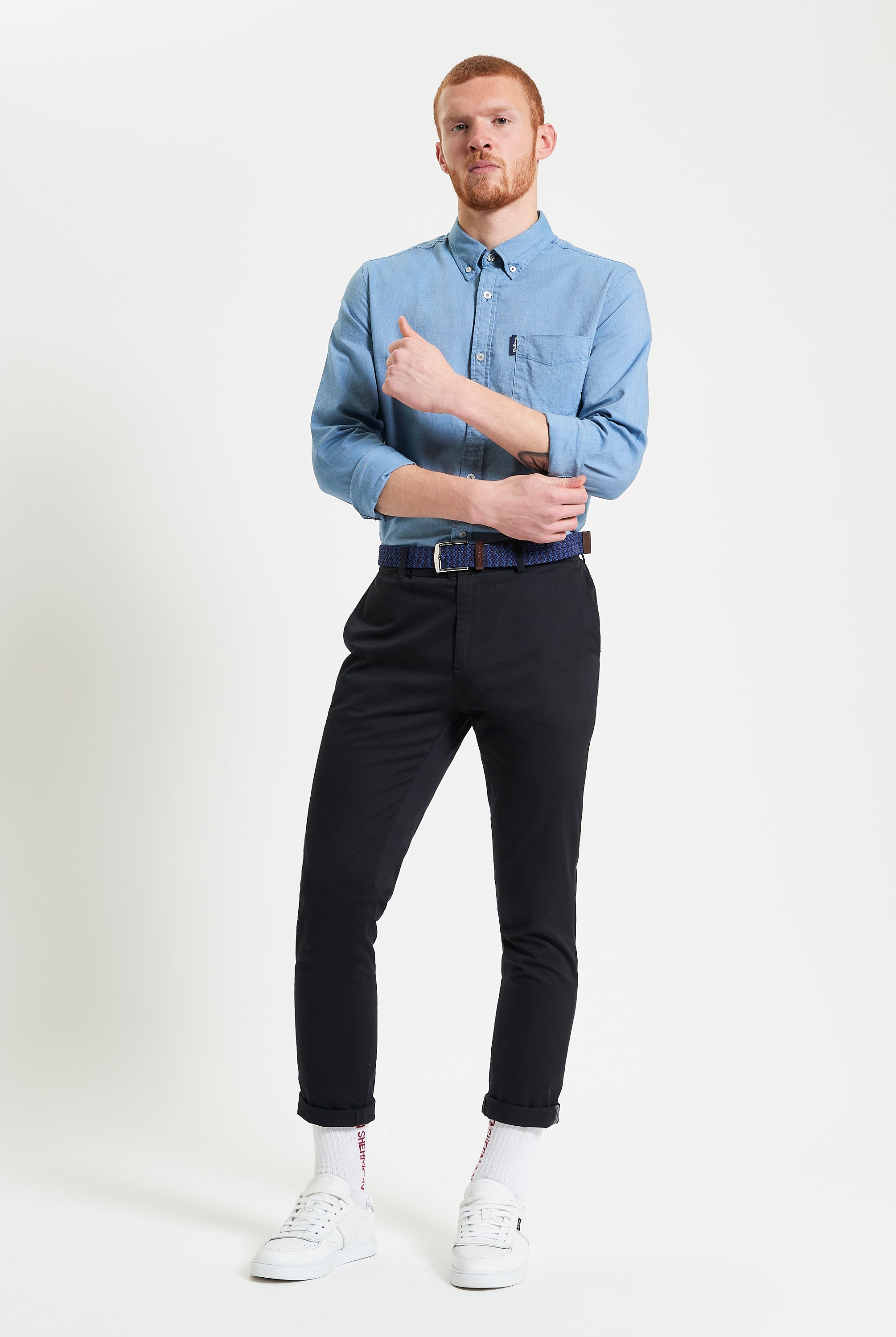 Model wearing a Signature Oxford Long Sleeve Shirt with black pants and white sneakers, showcasing a stylish casual look.