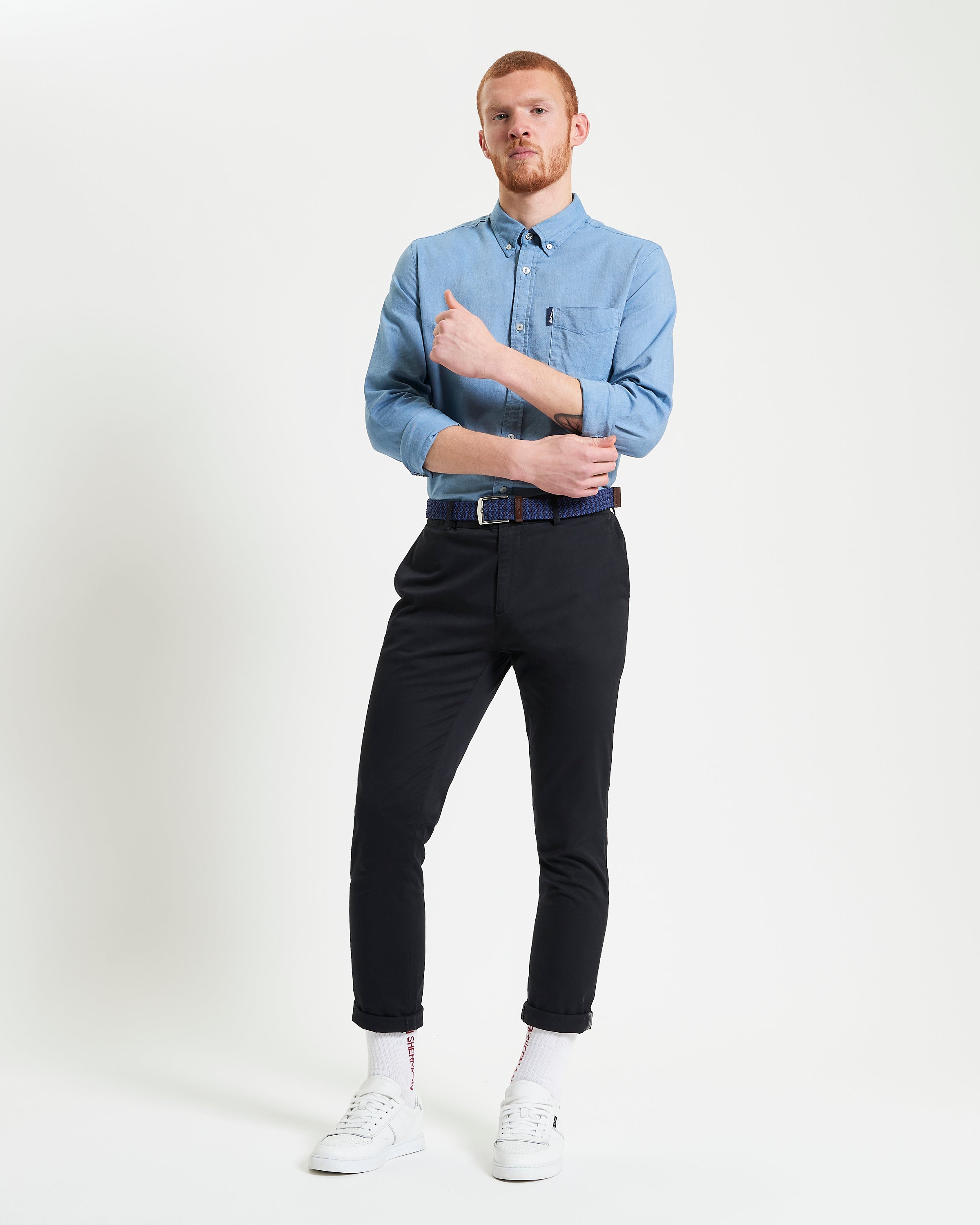 Model wearing a Signature Oxford Long Sleeve Shirt with black pants and white sneakers, showcasing a stylish casual look.