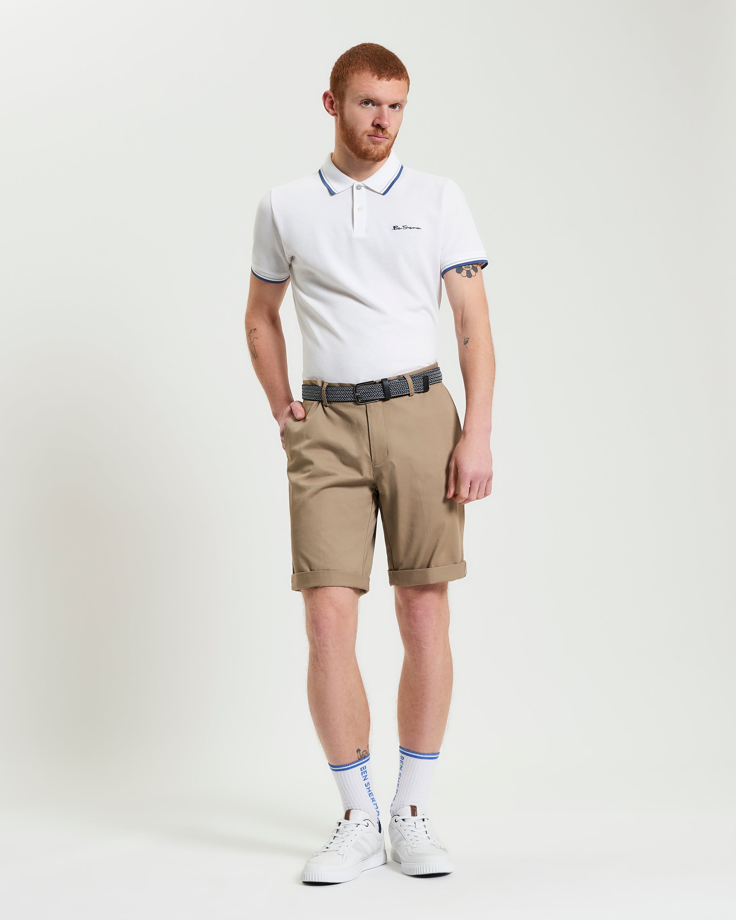 Model wearing Signature Chino Short in beige with white polo shirt and belt for a stylish summer look.