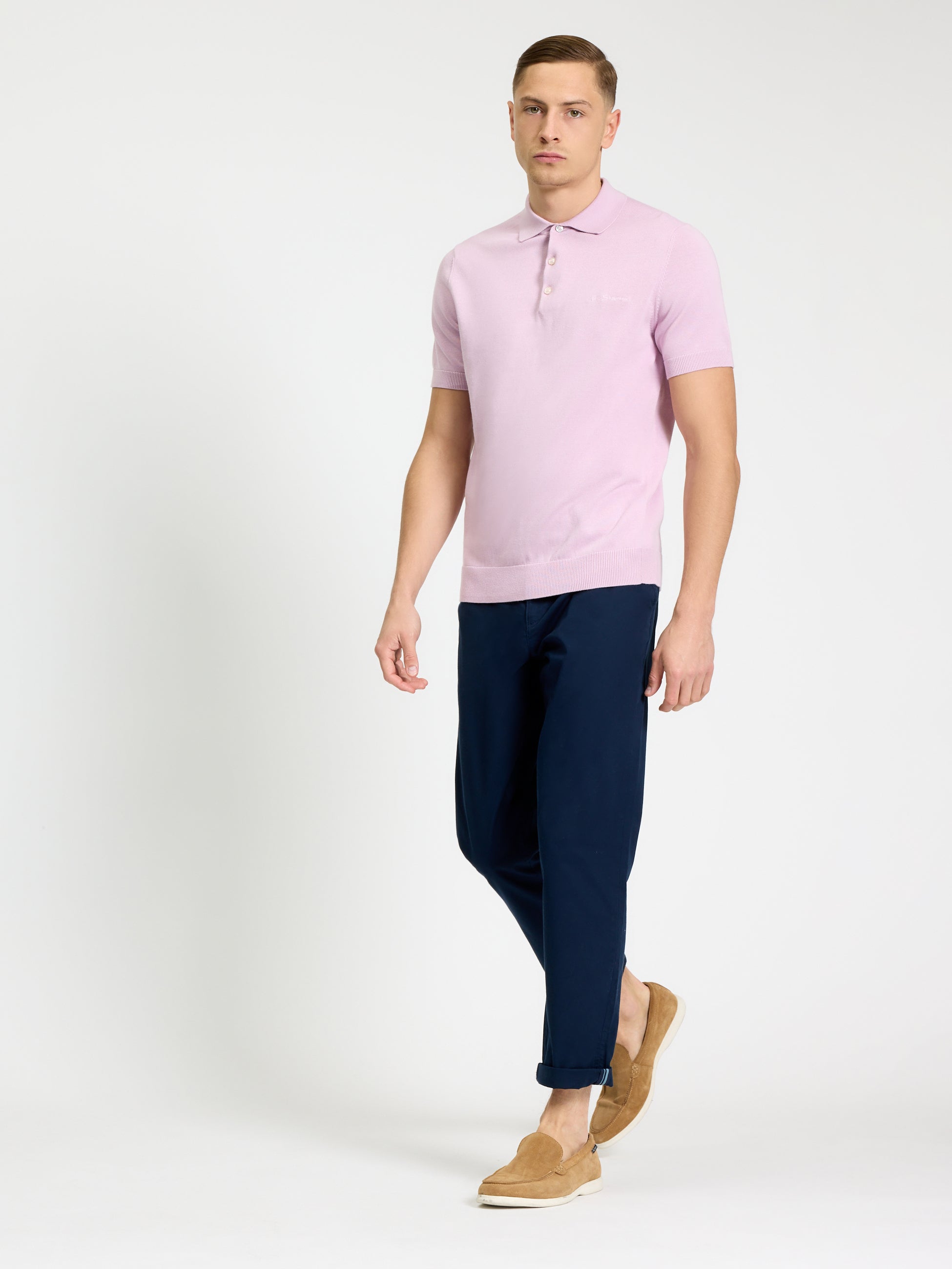 Model wearing the Signature Short Sleeve Polo in pink with navy pants and slip-on shoes.
