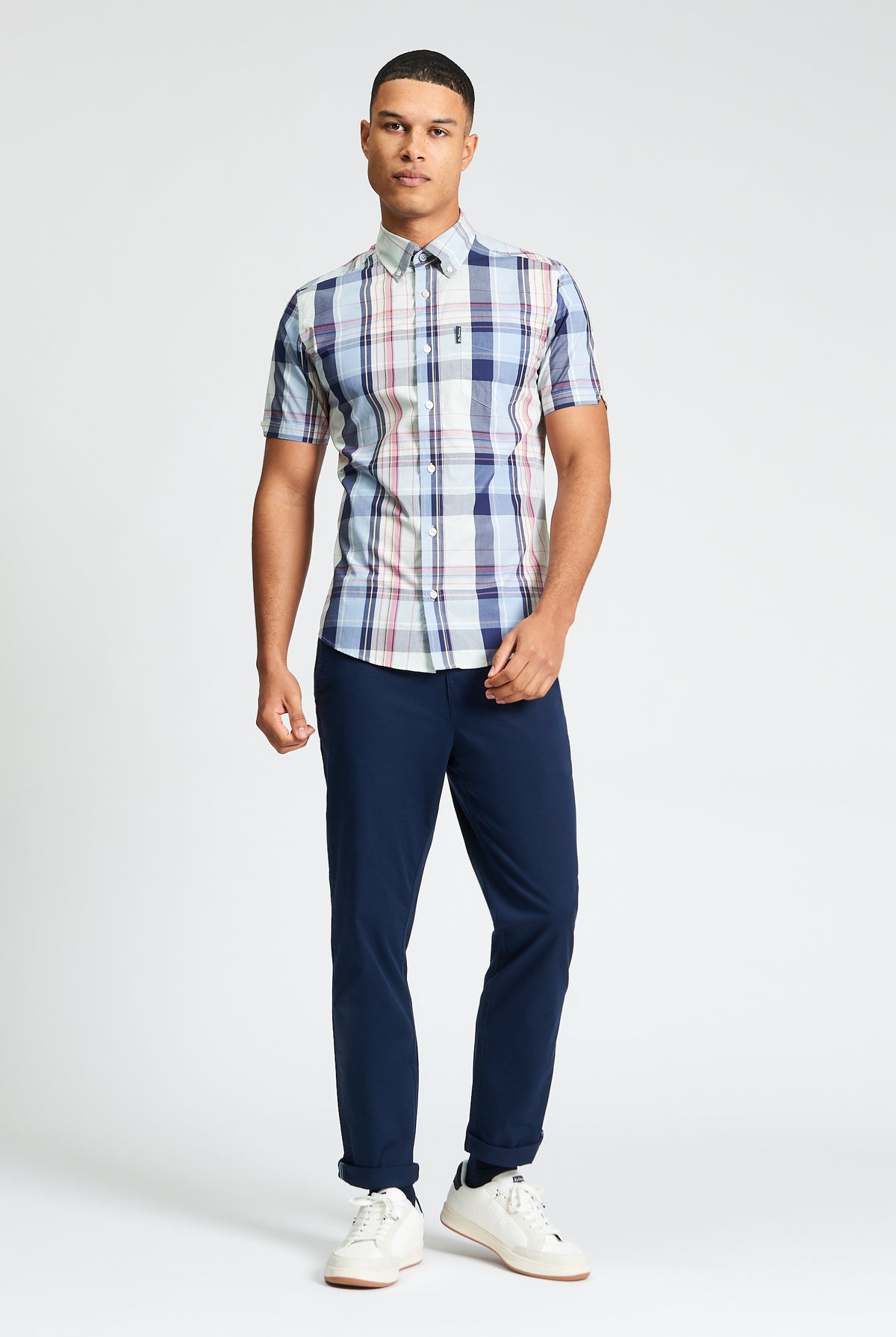 Young man in an Oversized Check shirt, showcasing a relaxed yet stylish look with navy pants.