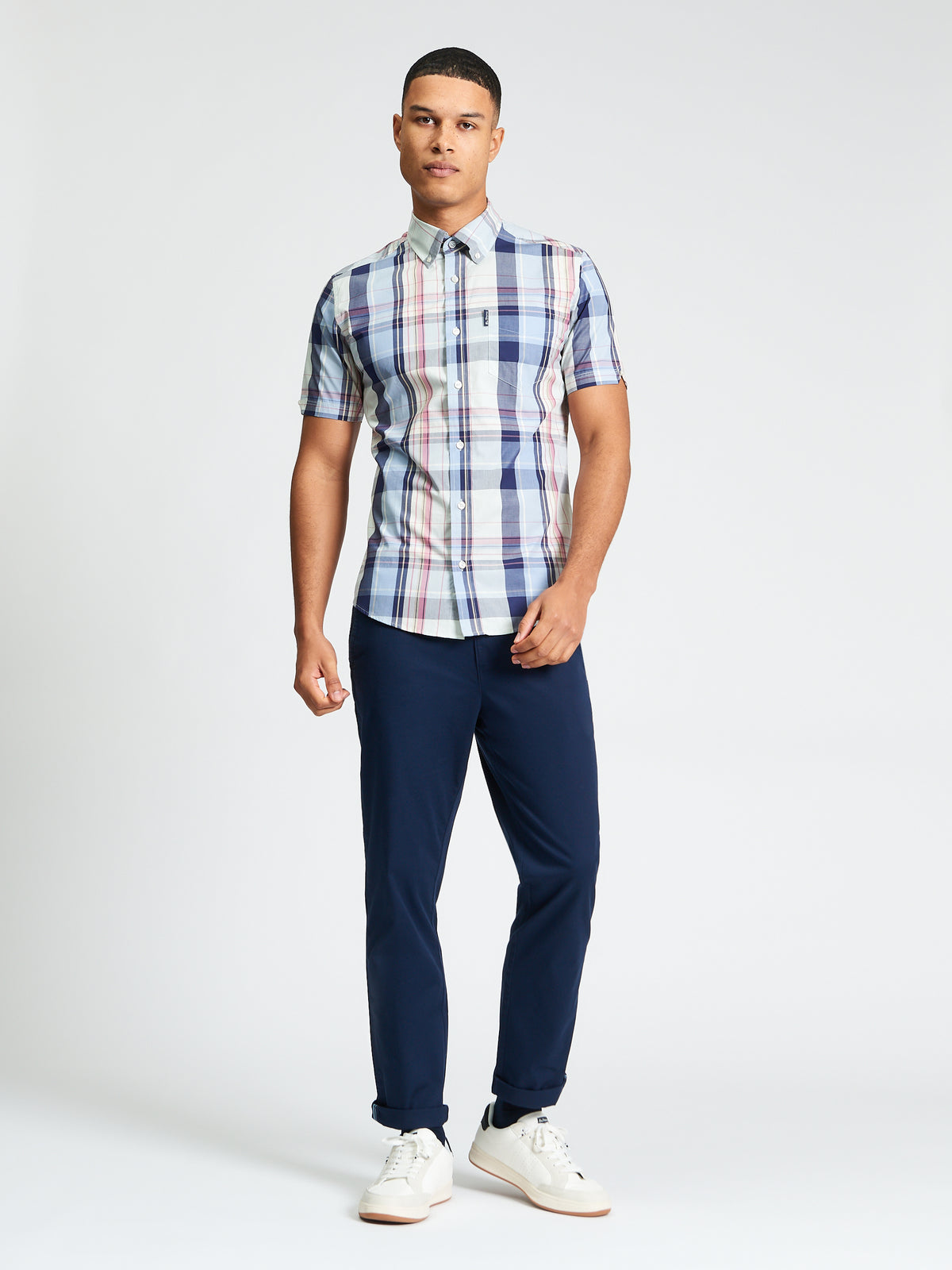 Young man in an Oversized Check shirt, showcasing a relaxed yet stylish look with navy pants.