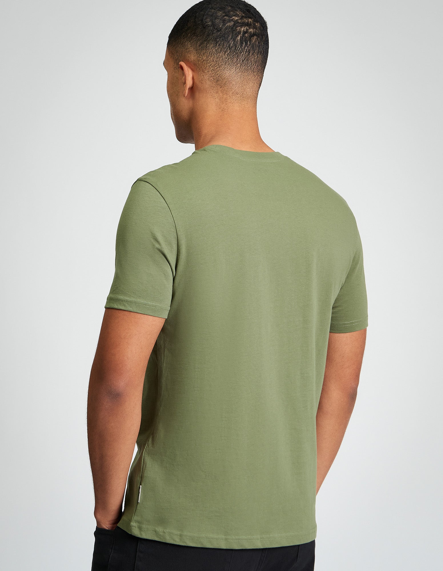 Back view of a man wearing a Seagull Target Tee in green, showcasing its organic cotton fabric and regular fit.