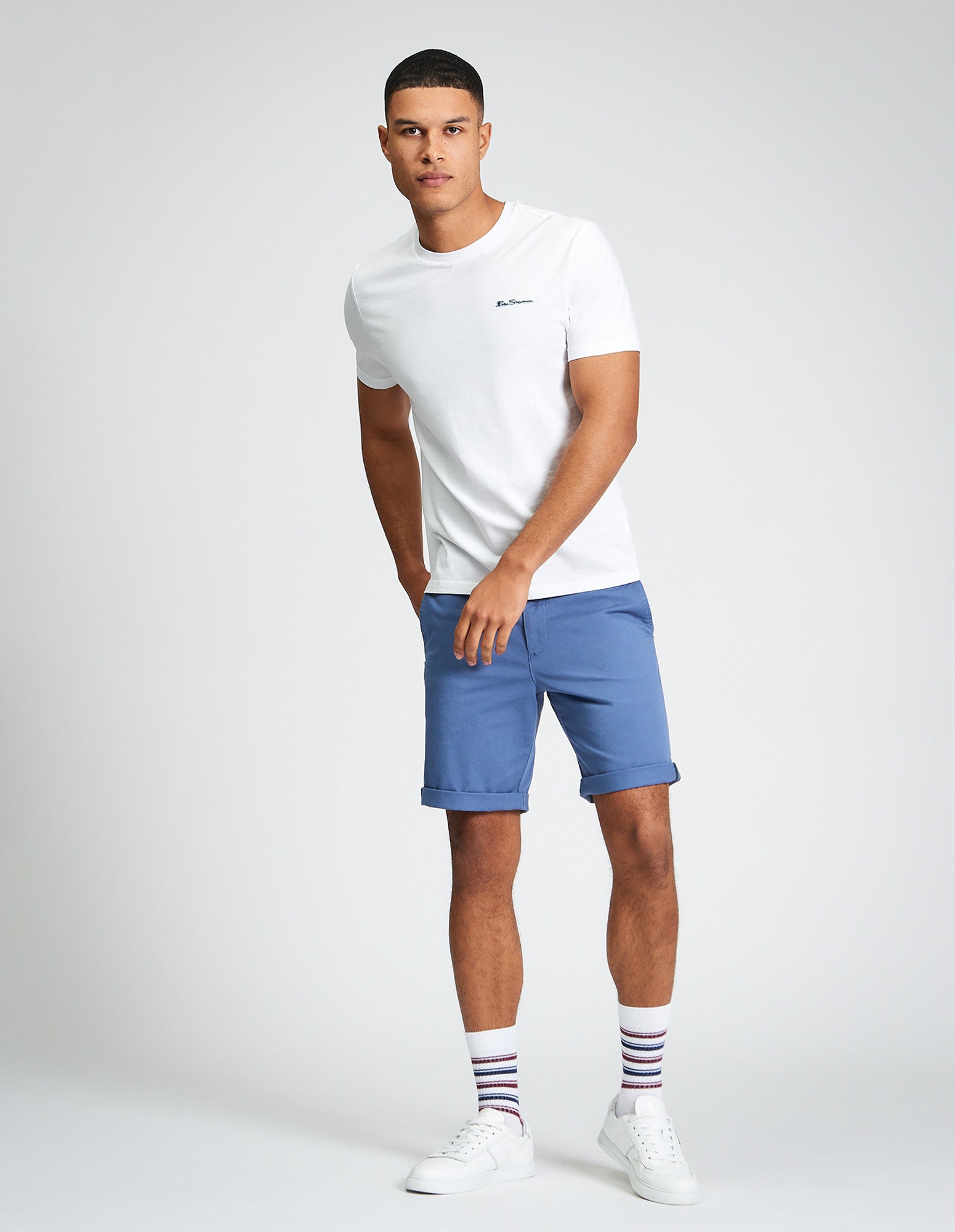 Signature Chino Short β blue shorts paired with a white tee and striped socks for a stylish summer look.