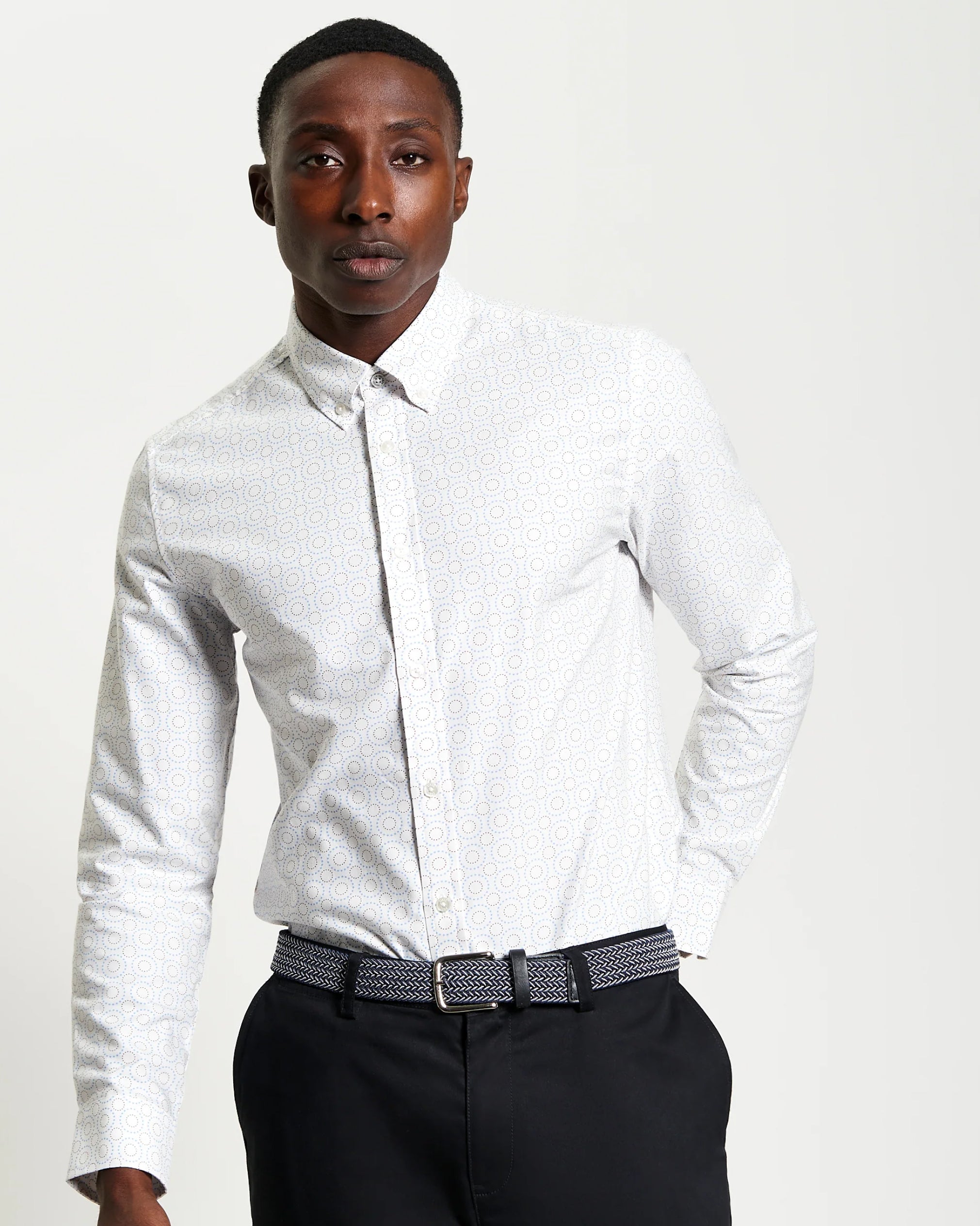 Man wearing Ben Sherman Stipple Spot Print shirt with a patterned tie and black pants on a plain background