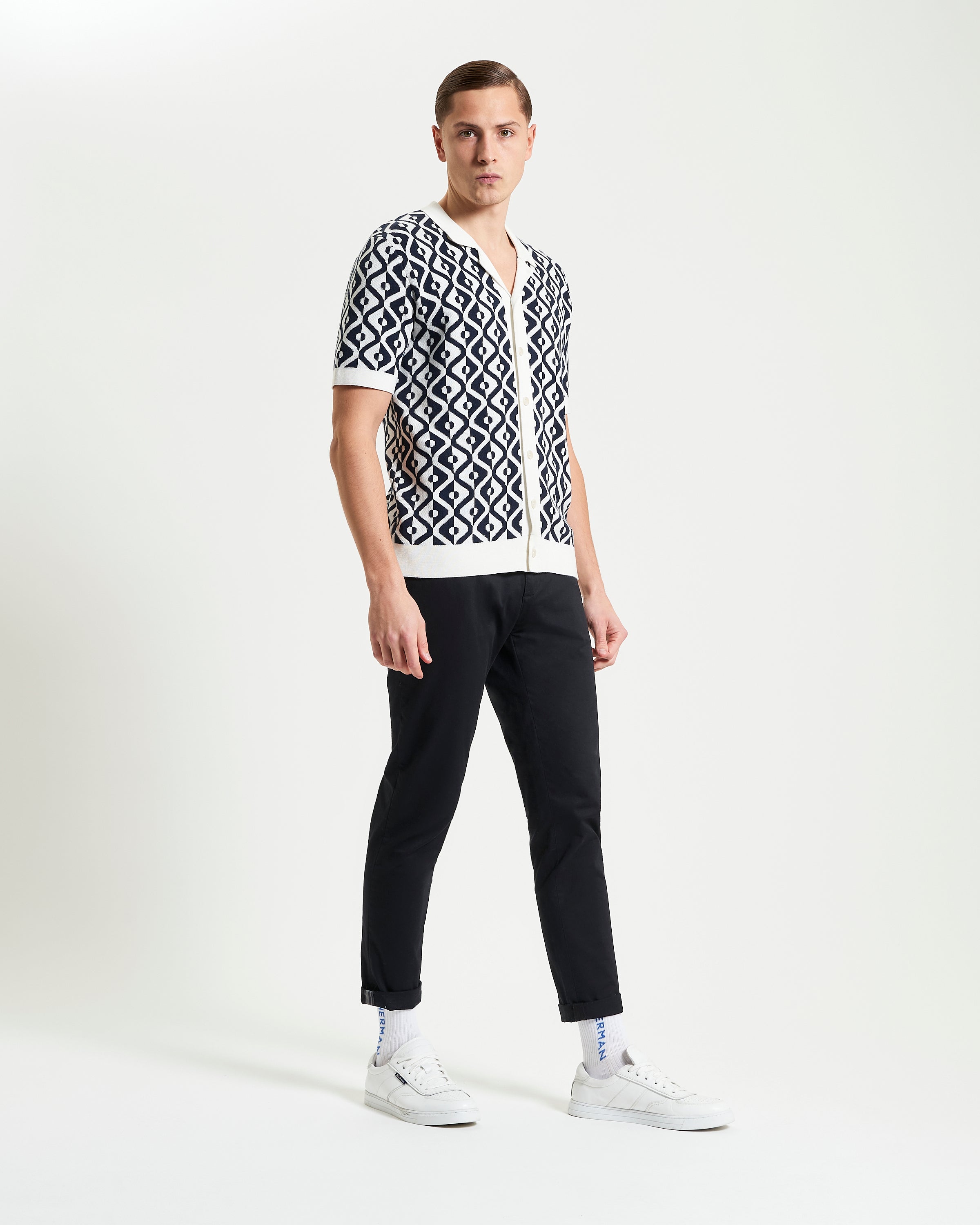 A model wearing the Tile Resort Knitted Shirt, showcasing a tile jacquard design, relaxed fit, and short sleeves.