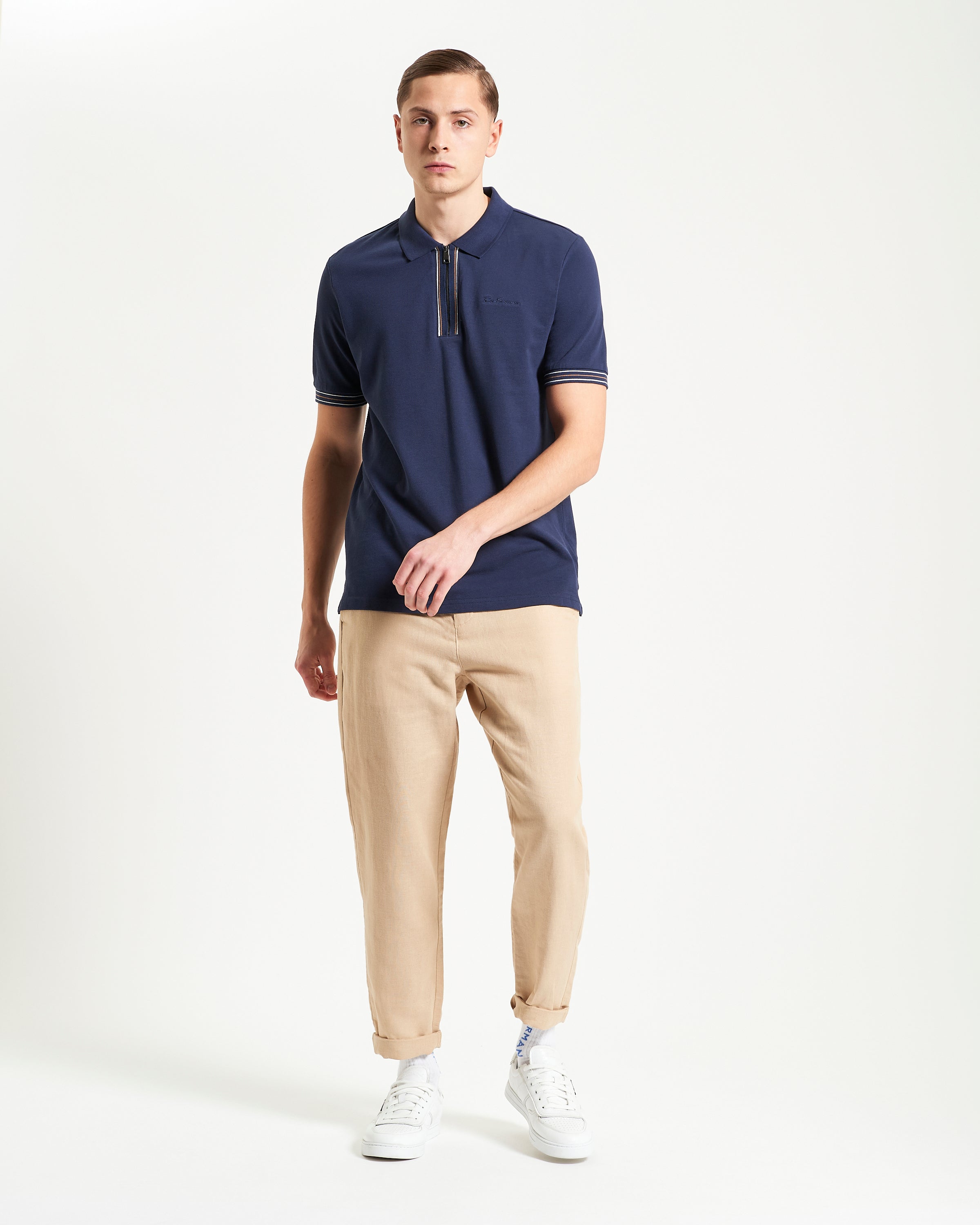 Placket Interest Polo – navy blue polo shirt with zip fastening and contrast striped cuffs.