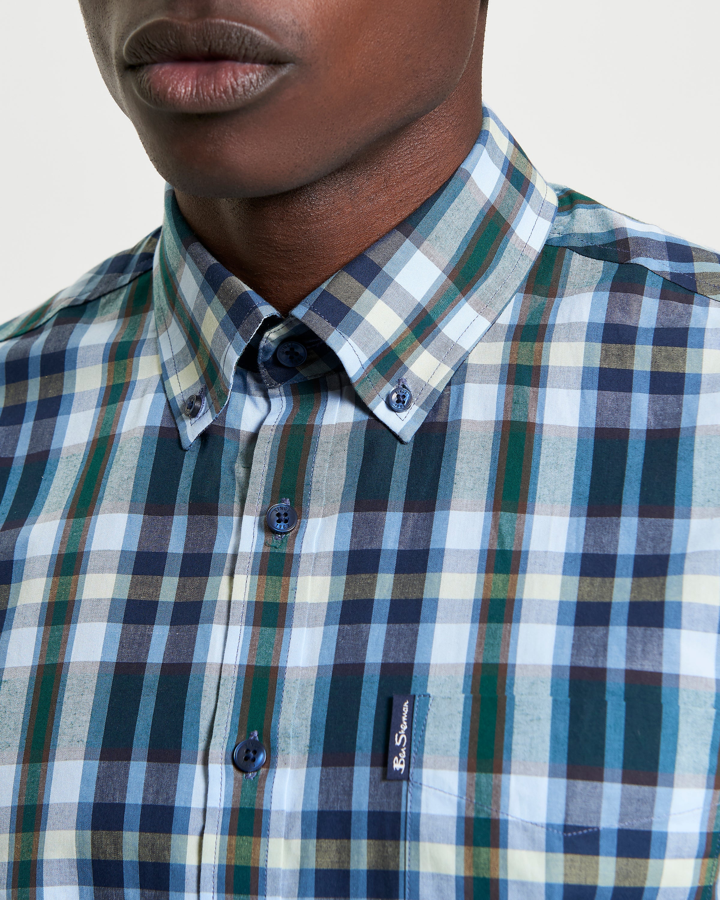 Irregular Check shirt featuring curved hem and button-down collar, perfect for a modern casual wardrobe.