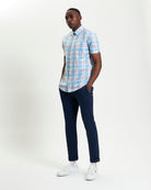Irregular Check shirt in blue and pink plaid worn with navy pants for a stylish casual look.