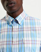 Irregular Check shirt featuring a three-finger button-down collar and curved hem, made from 100% organic cotton.