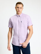 Signature Oxford Short Sleeve Shirt – lightweight purple shirt on model with button-down collar and chest pocket.