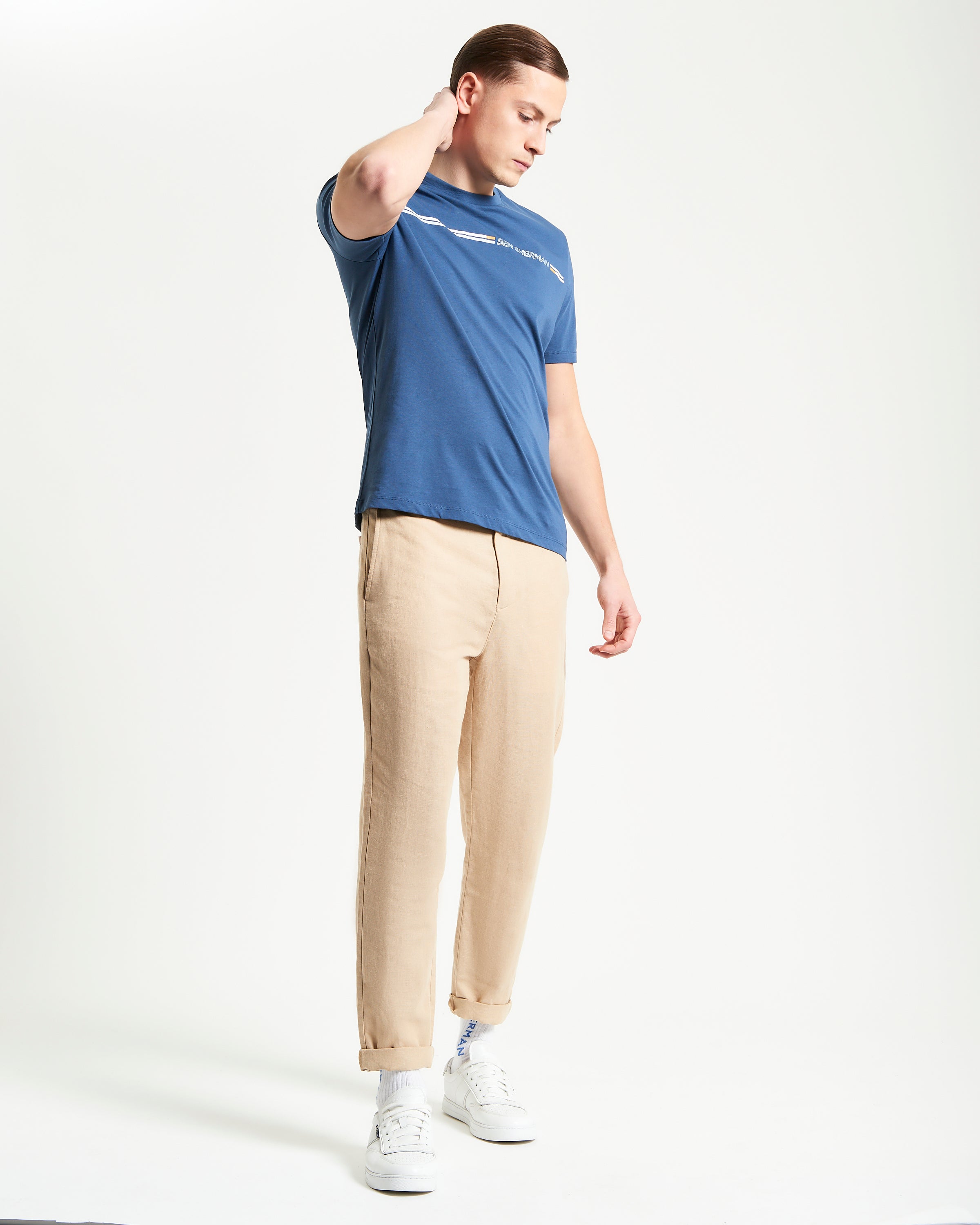 Core Striped Tee – blue t-shirt with seasonal stripes, paired with light pants, showcasing sustainable fashion.