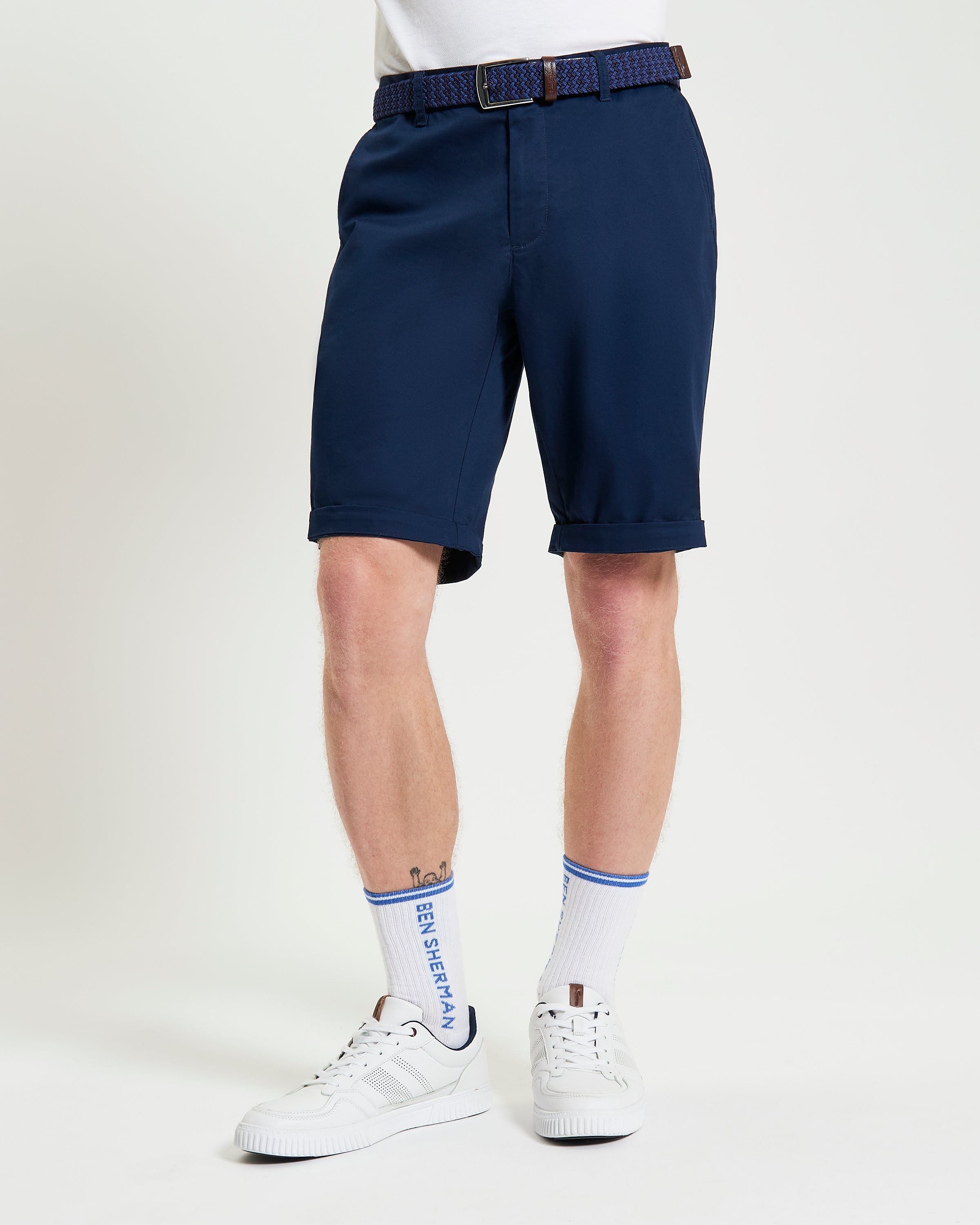 Signature Chino Short – navy blue chino shorts with a tailored fit, featuring a stylish belt and sporty socks.