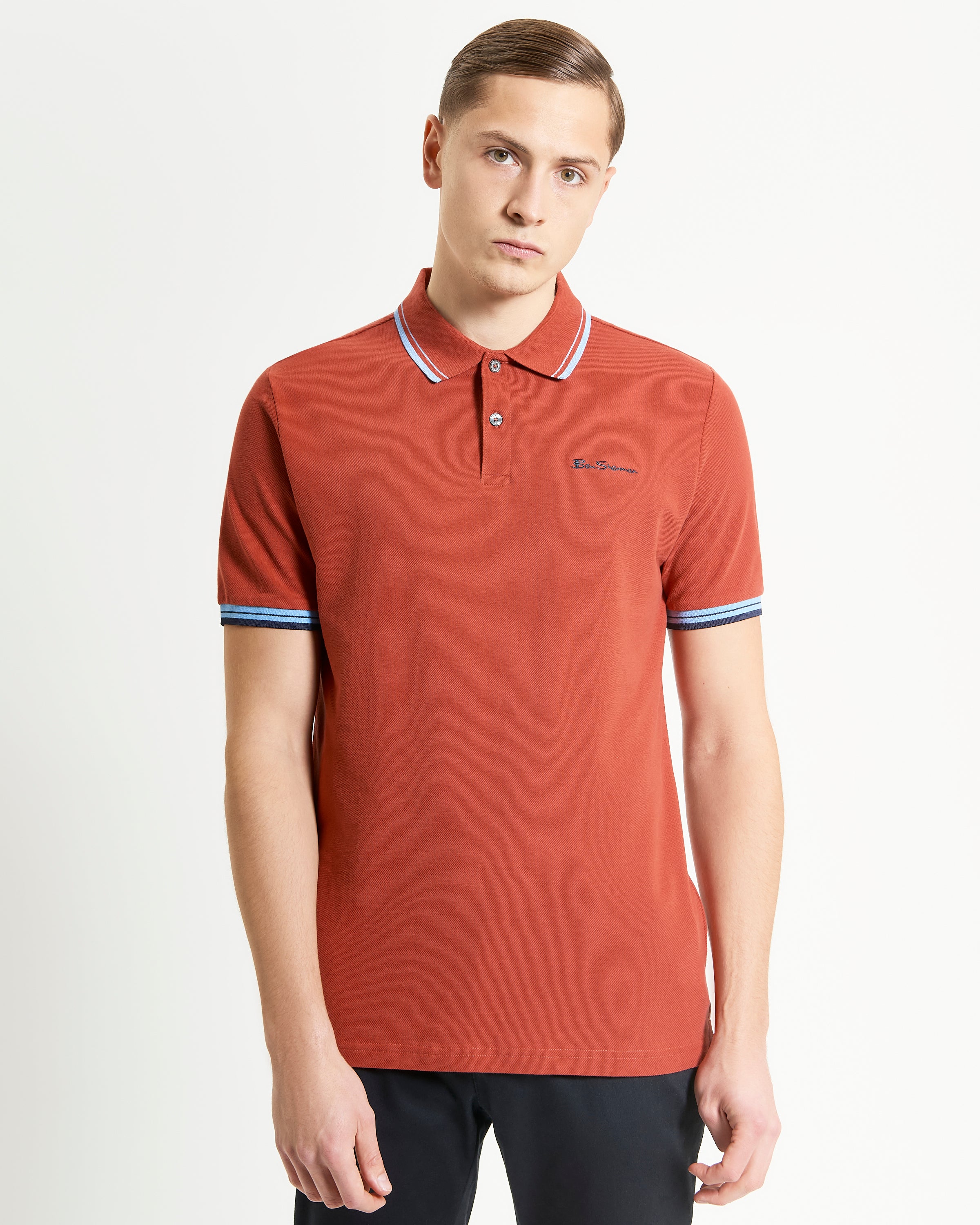 Signature Pique Polo – Red with contrast detailing, showcasing a model in a refined casual wear setting.