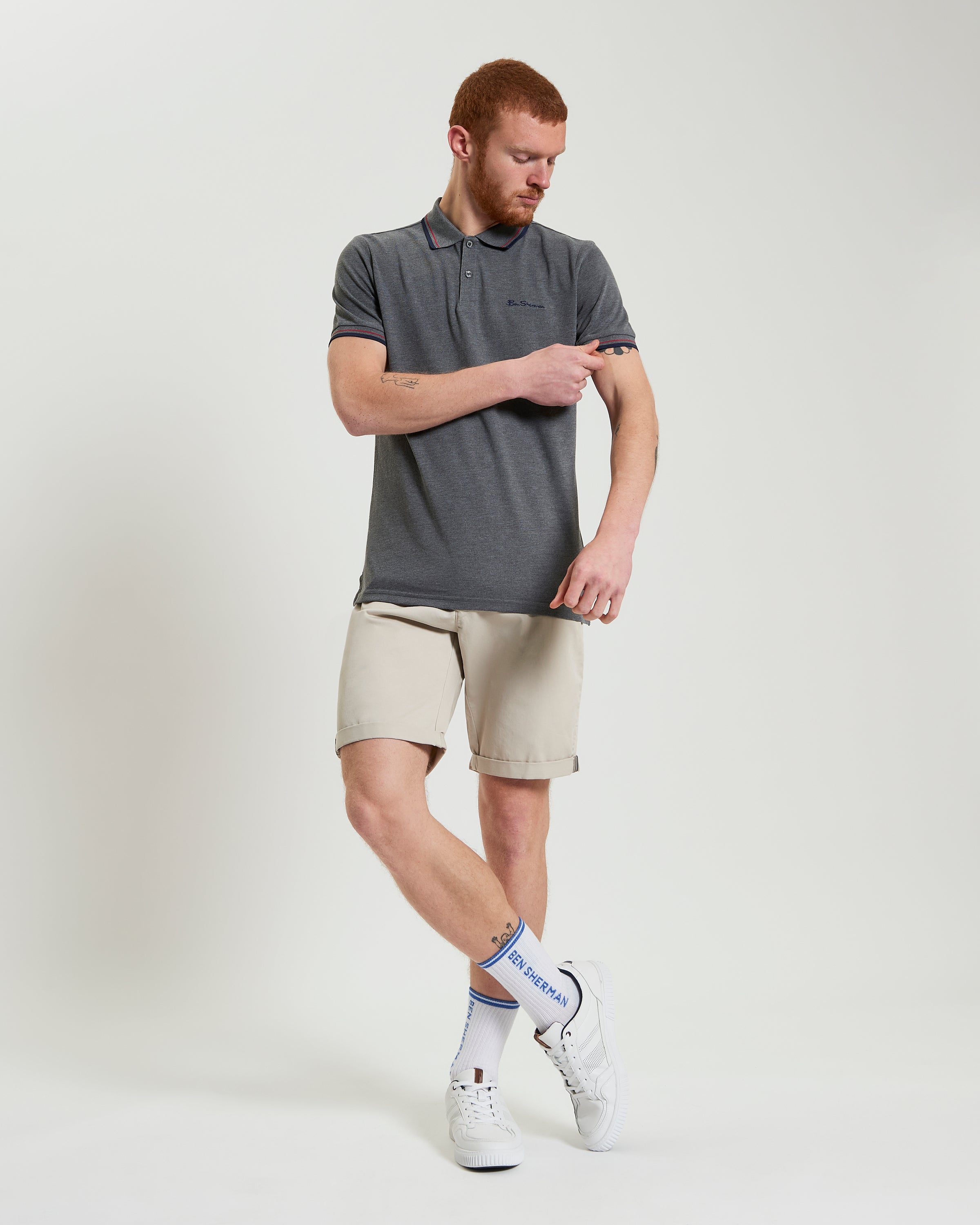 Signature Chino Short – smart summer outfit featuring a man in chino shorts and a grey polo shirt.
