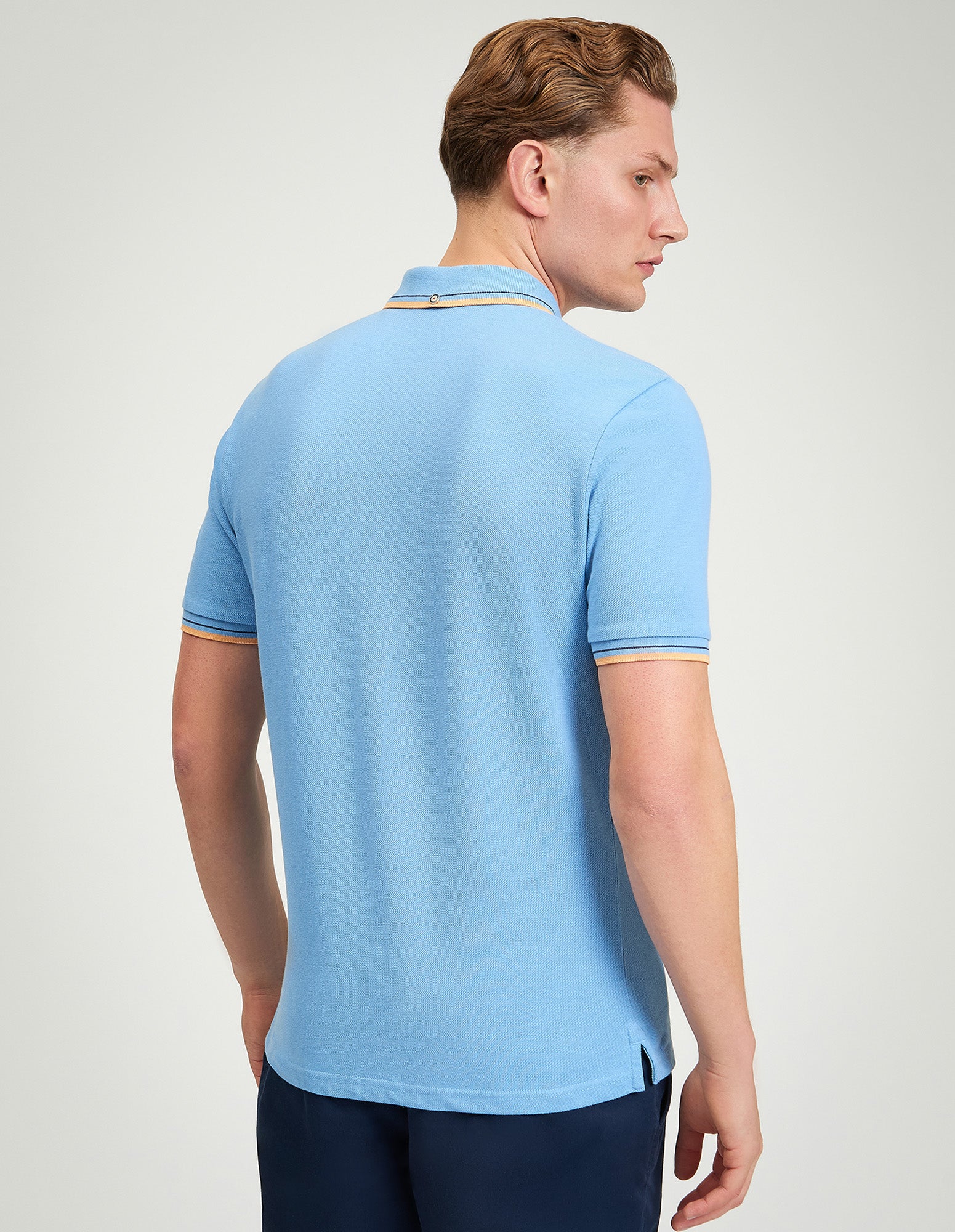 Signature Pique Polo – Back view of a man wearing a light blue polo shirt featuring contrast detailing.