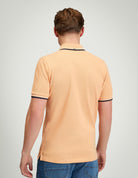 Signature Pique Polo – back view of a man wearing a peach polo shirt with contrast detailing.