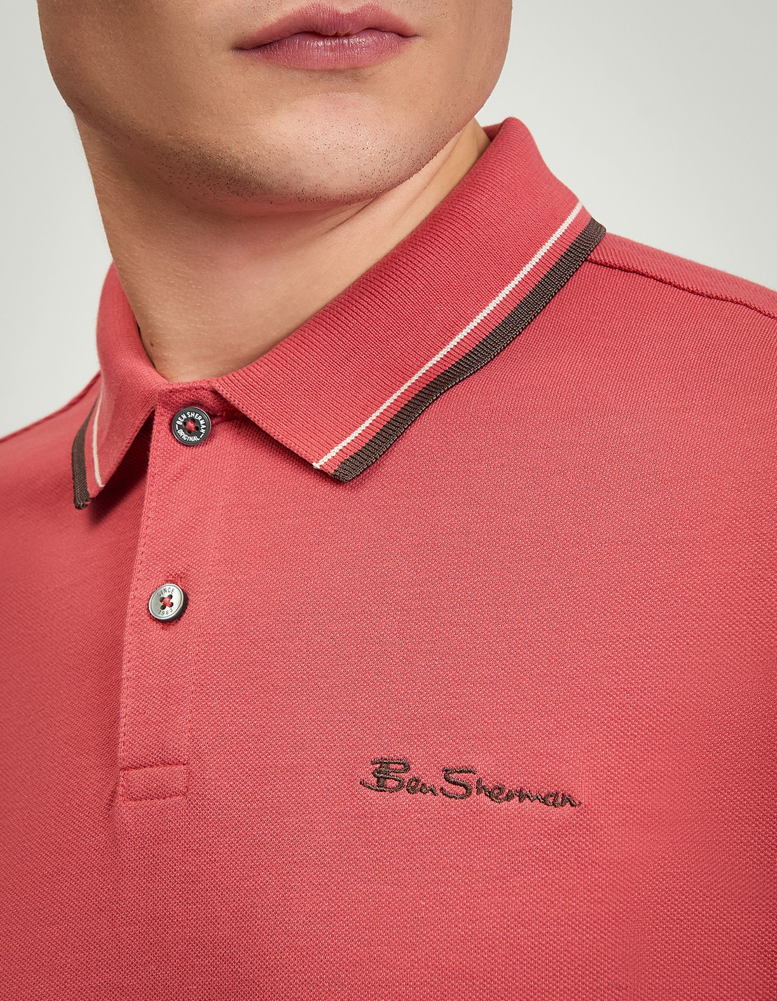 Close-up of the Signature Pique Polo in pink with contrasting collar and Ben Sherman logo.