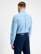 Back view of a man wearing a Linear Gingham Shirt by Ben Sherman, featuring a blue gingham pattern and curved hem.