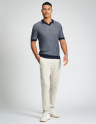 Bi Coloured Textured Polo – navy and grey textured design on model with beige pants.