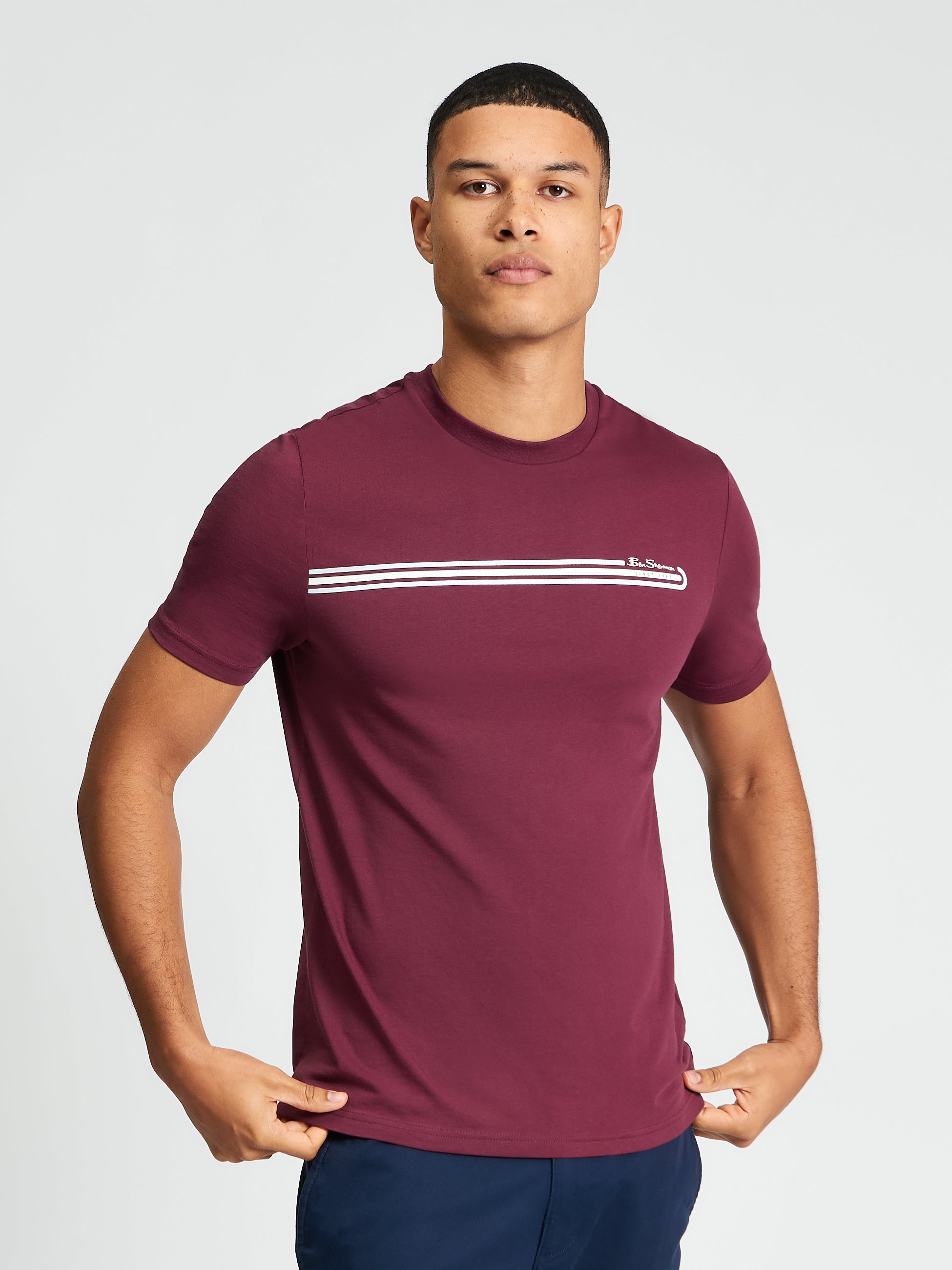 Core Stripe Tee – burgundy color with printed stripes across the chest and regular fit.