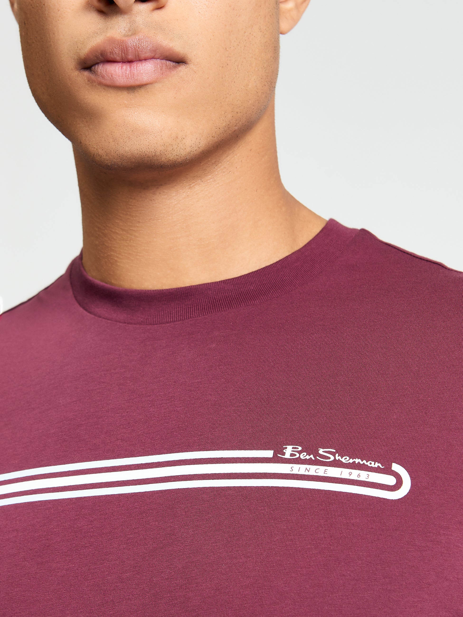Close-up of a man wearing the Core Stripe Tee by Ben Sherman, featuring a bold stripe design and branded label.