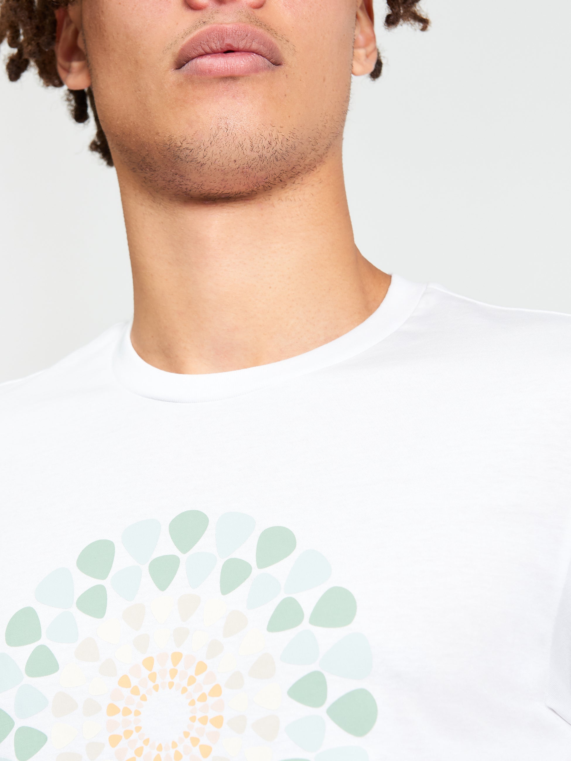 Close-up of a model wearing a Plectrum Target Tee featuring colorful graphic design on a white shirt.