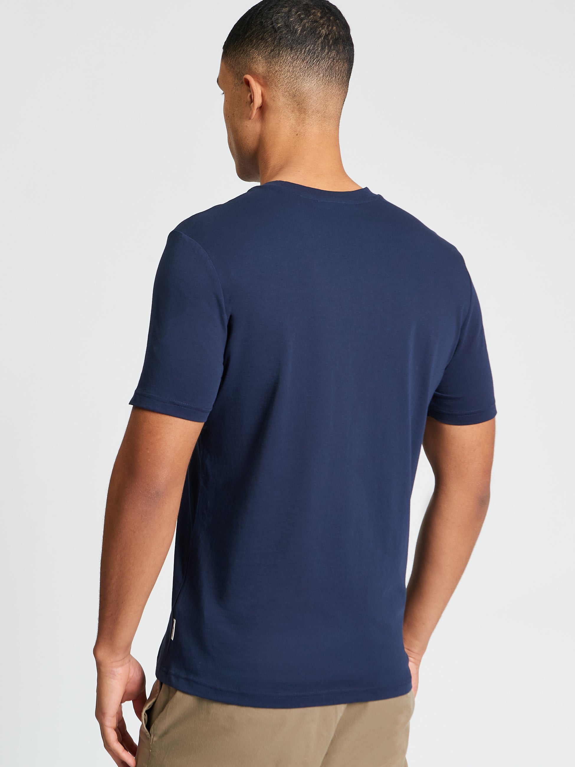 Plectrum Target Tee back view, showcasing the navy blue organic cotton fabric and signature branding detail.