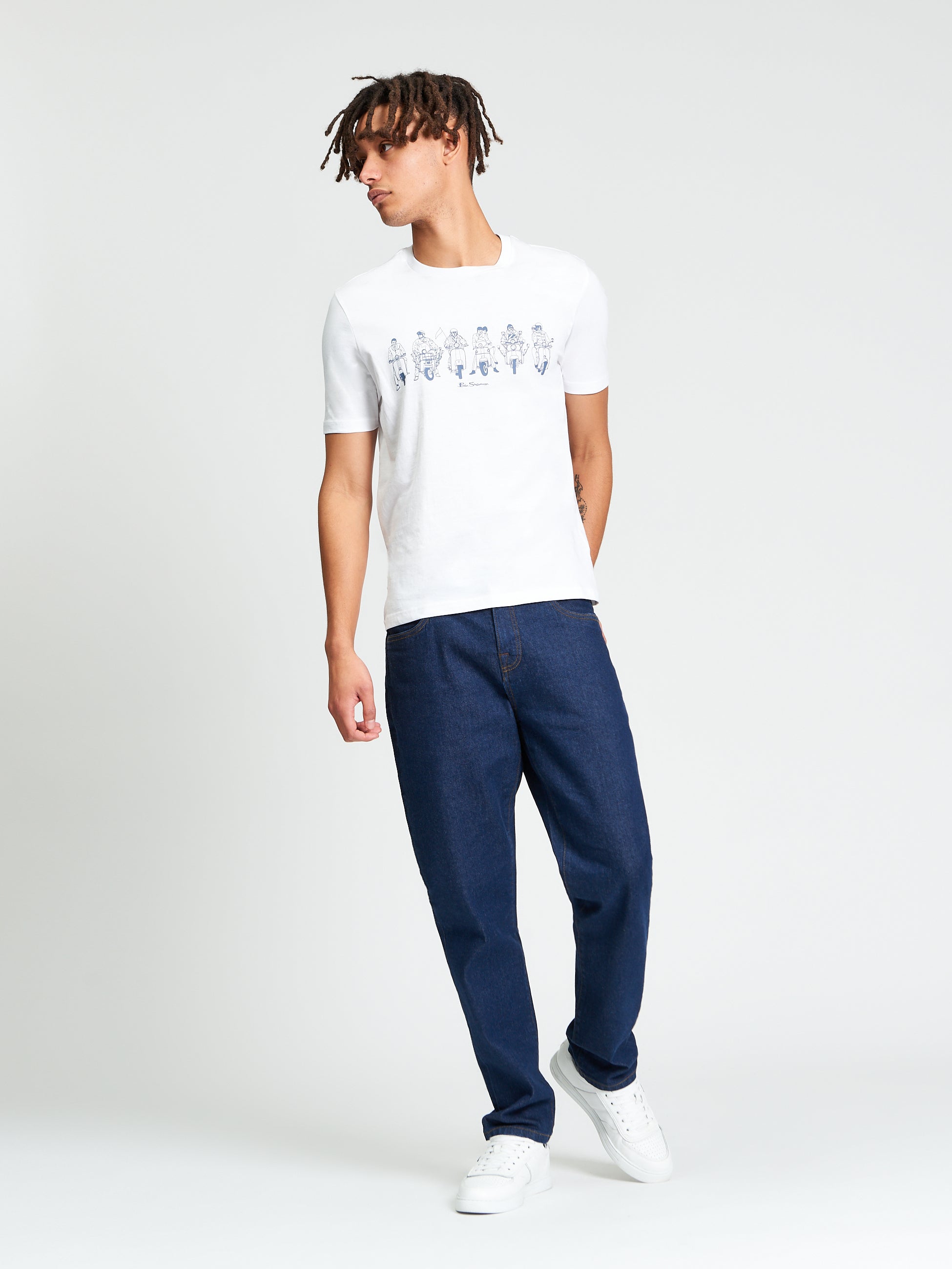 The Start Line Tee worn by a model in white, featuring a bold graphic print, paired with dark jeans.