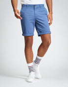 Signature Chino Short – Blue shorts with rolled cuffs, styled with a white t-shirt and patterned socks.