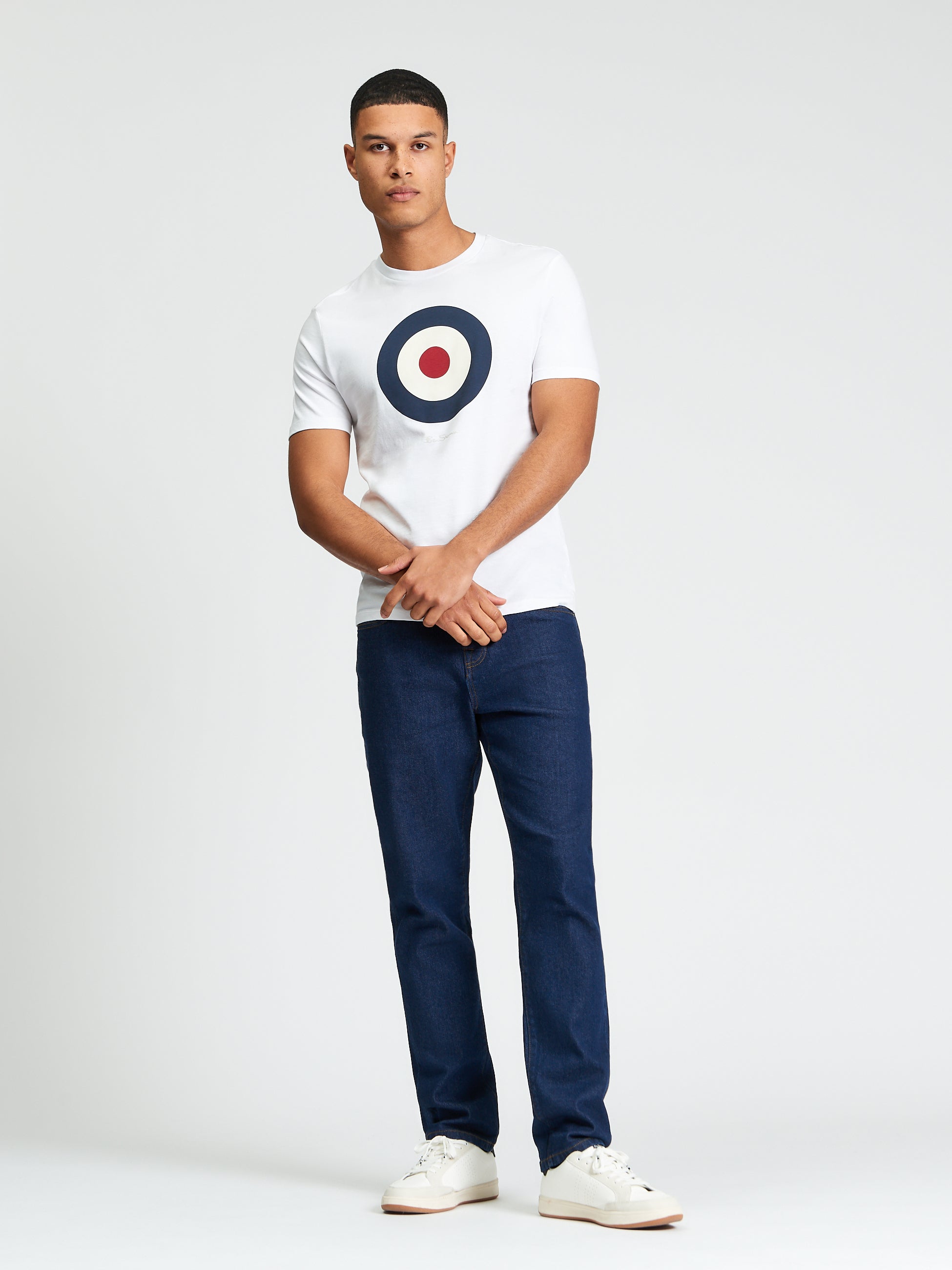 Slim Taper Denim – Model wearing casual t-shirt and slim taper denim jeans with white sneakers.