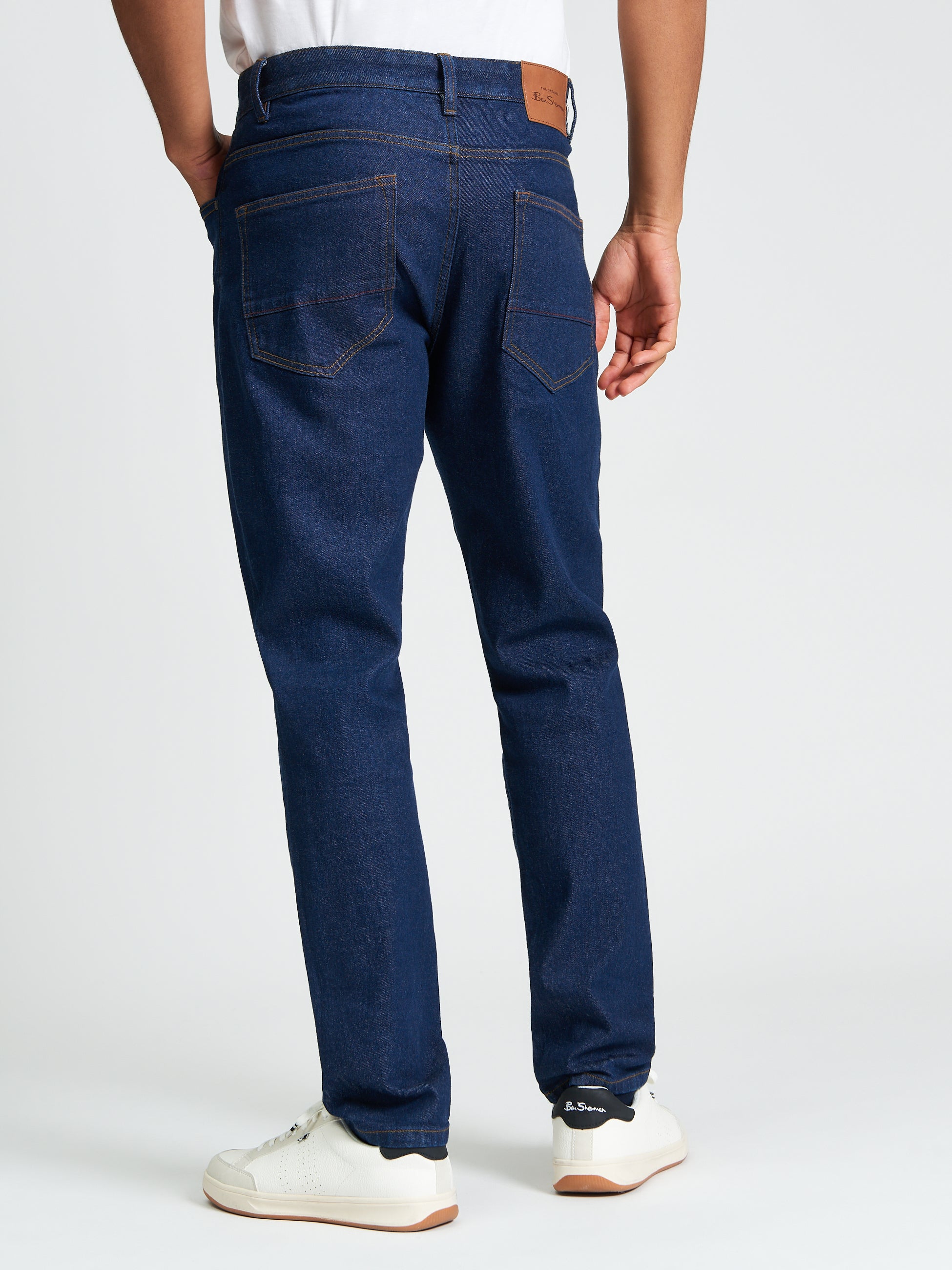 Slim Taper Denim – Back view showcasing five-pocket styling and branded details.