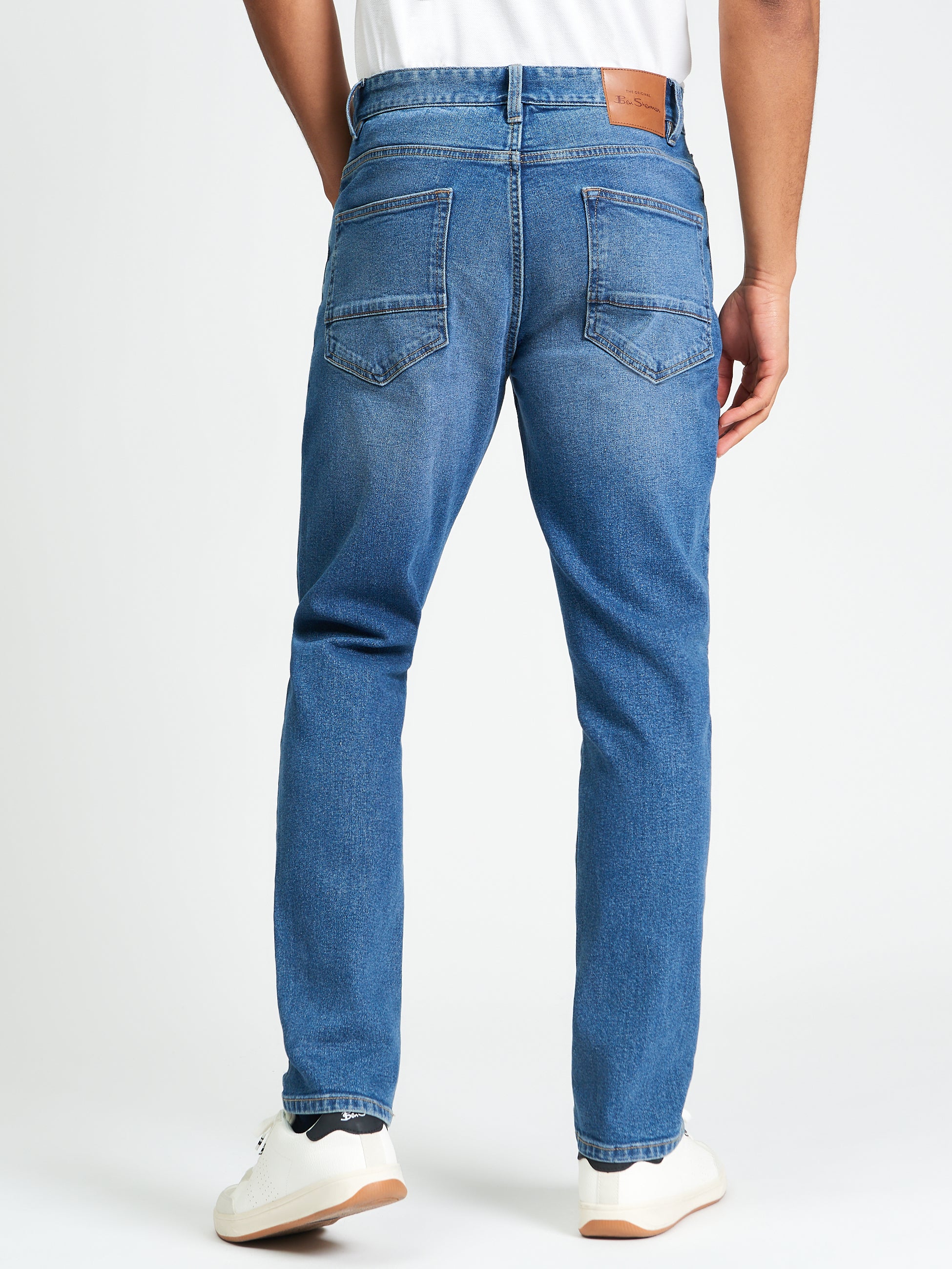 Slim Taper Denim – Back view of men's jeans with five-pocket styling and branded patch.